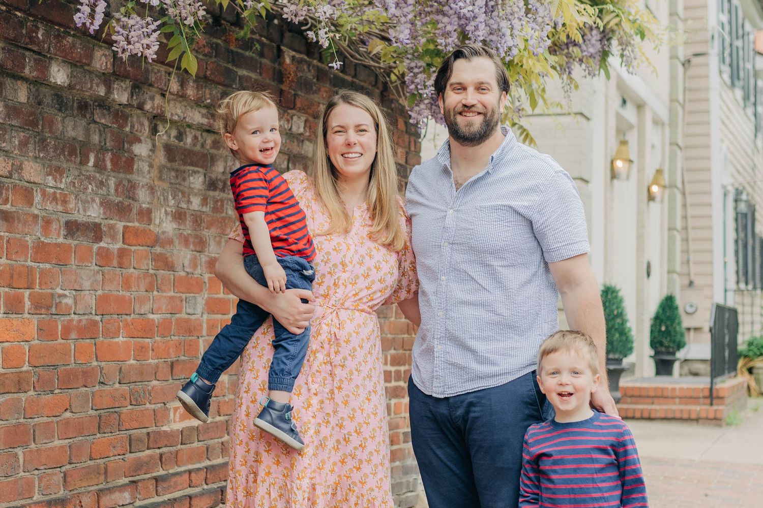 Family enjoying a spring day together under blooming cherry trees in an urban setting.