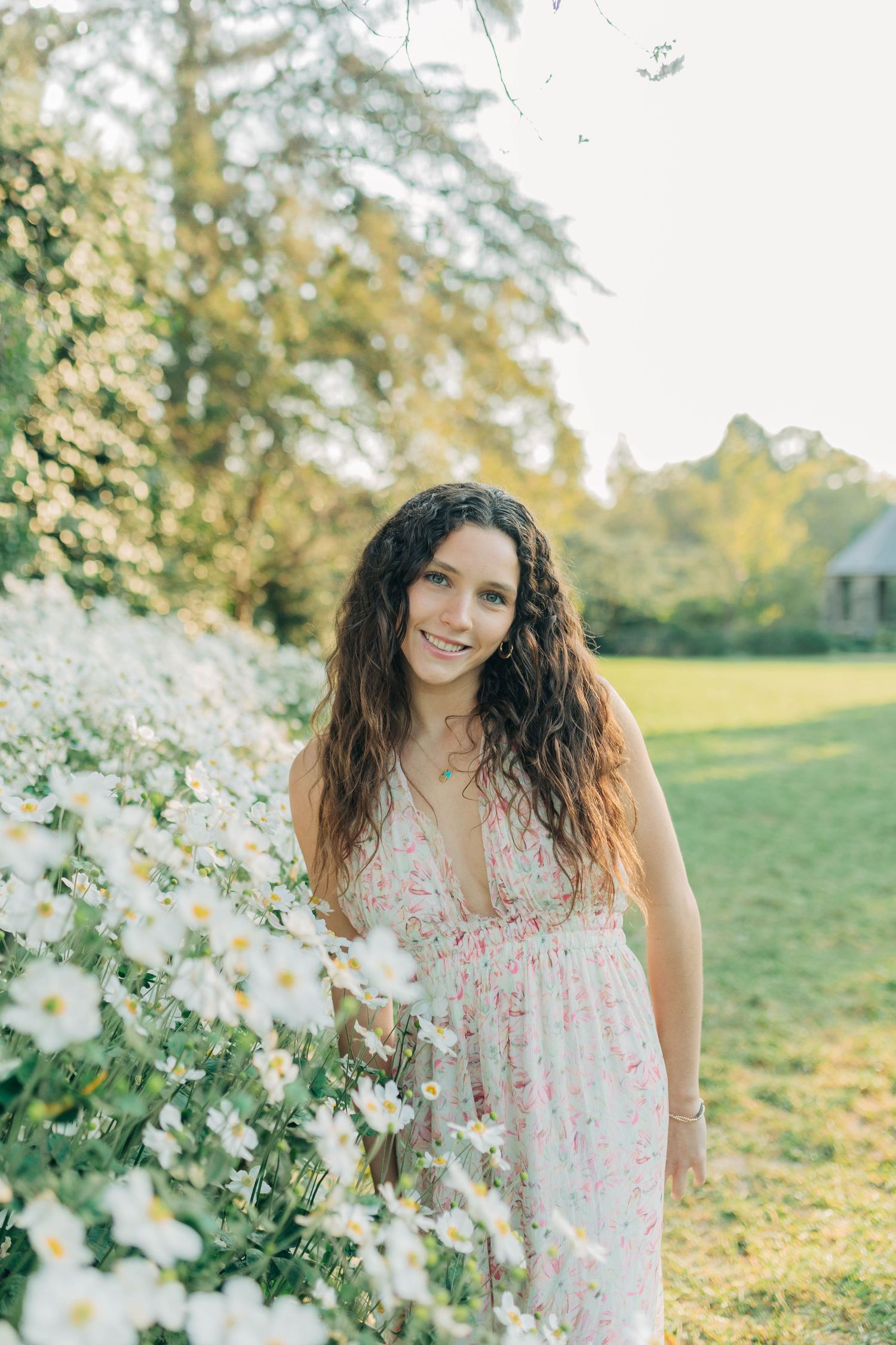 Flowering branches and golden sunlight create a dreamy spring portrait setting.