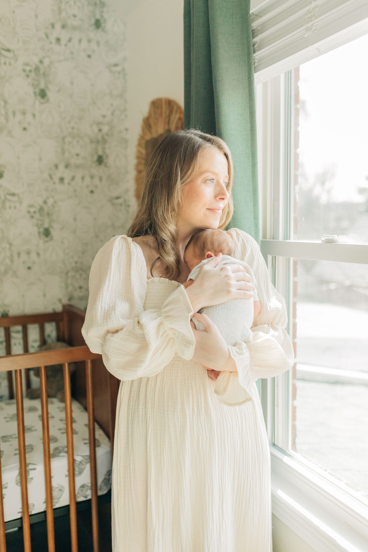 Ethereal nursery scene with natural light streaming through window beside wooden crib.