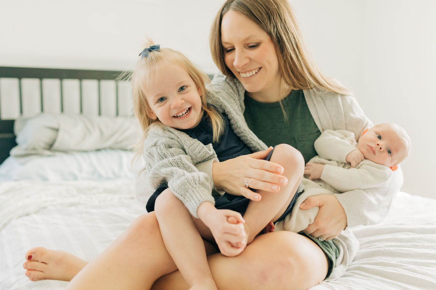 Candid family moment showing joy and laughter while relaxing together on bed.