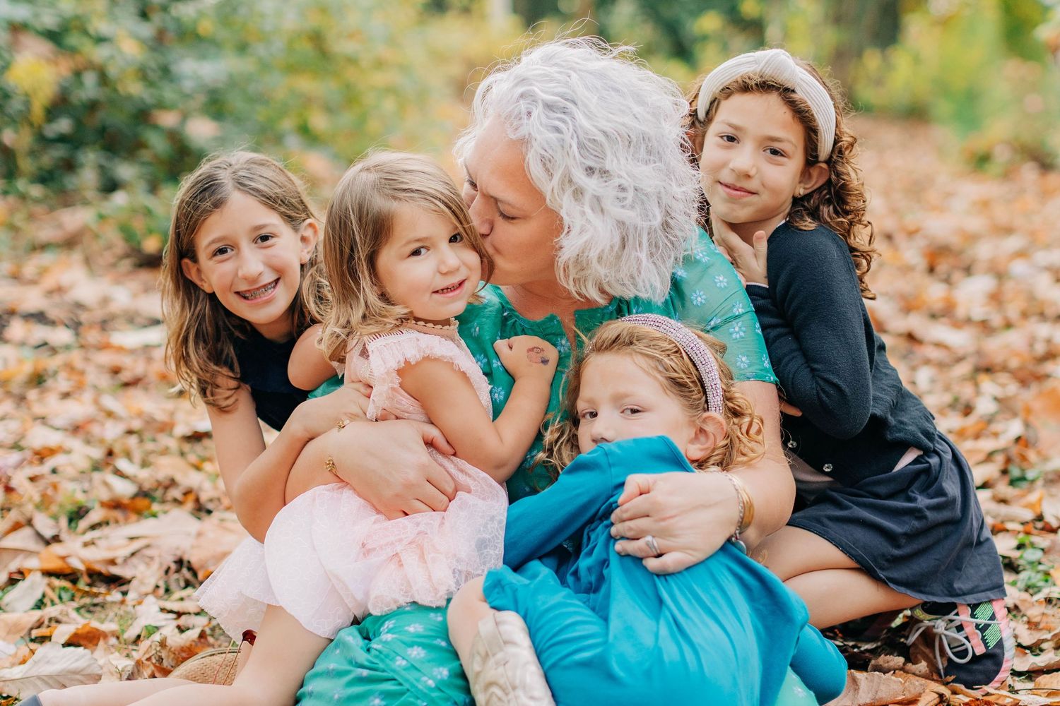 Family members embrace and share affectionate moments on a park bench.