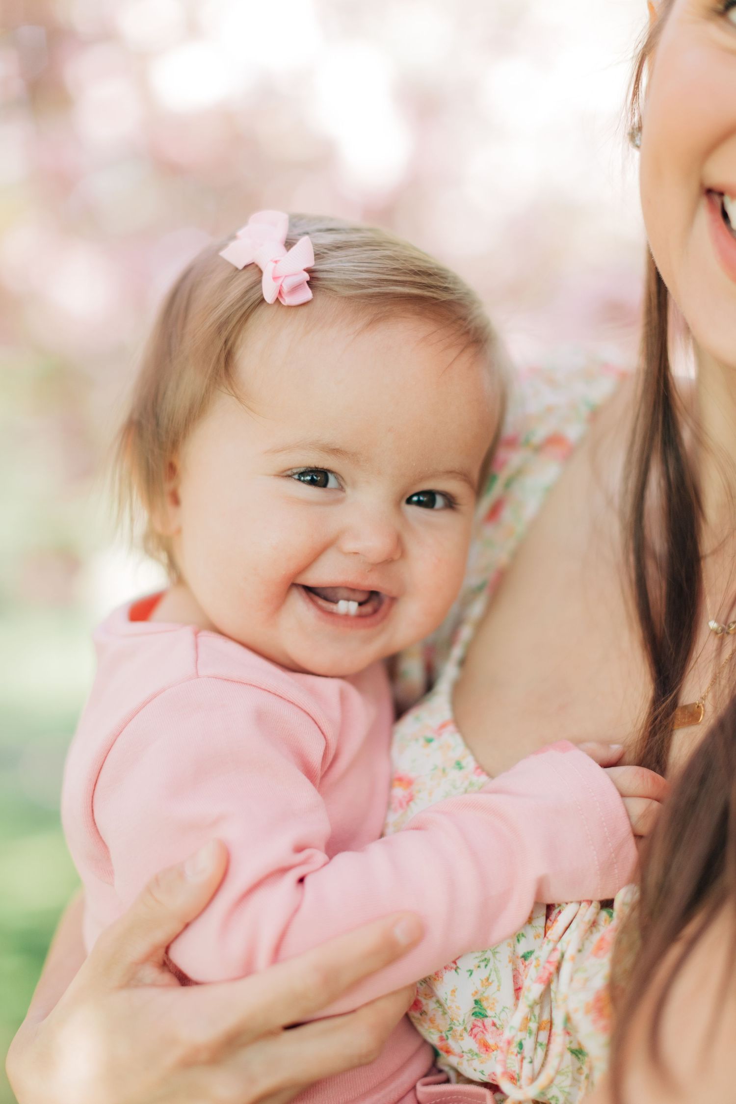 A close-up portrait showcasing joy and laughter under cherry blossoms.