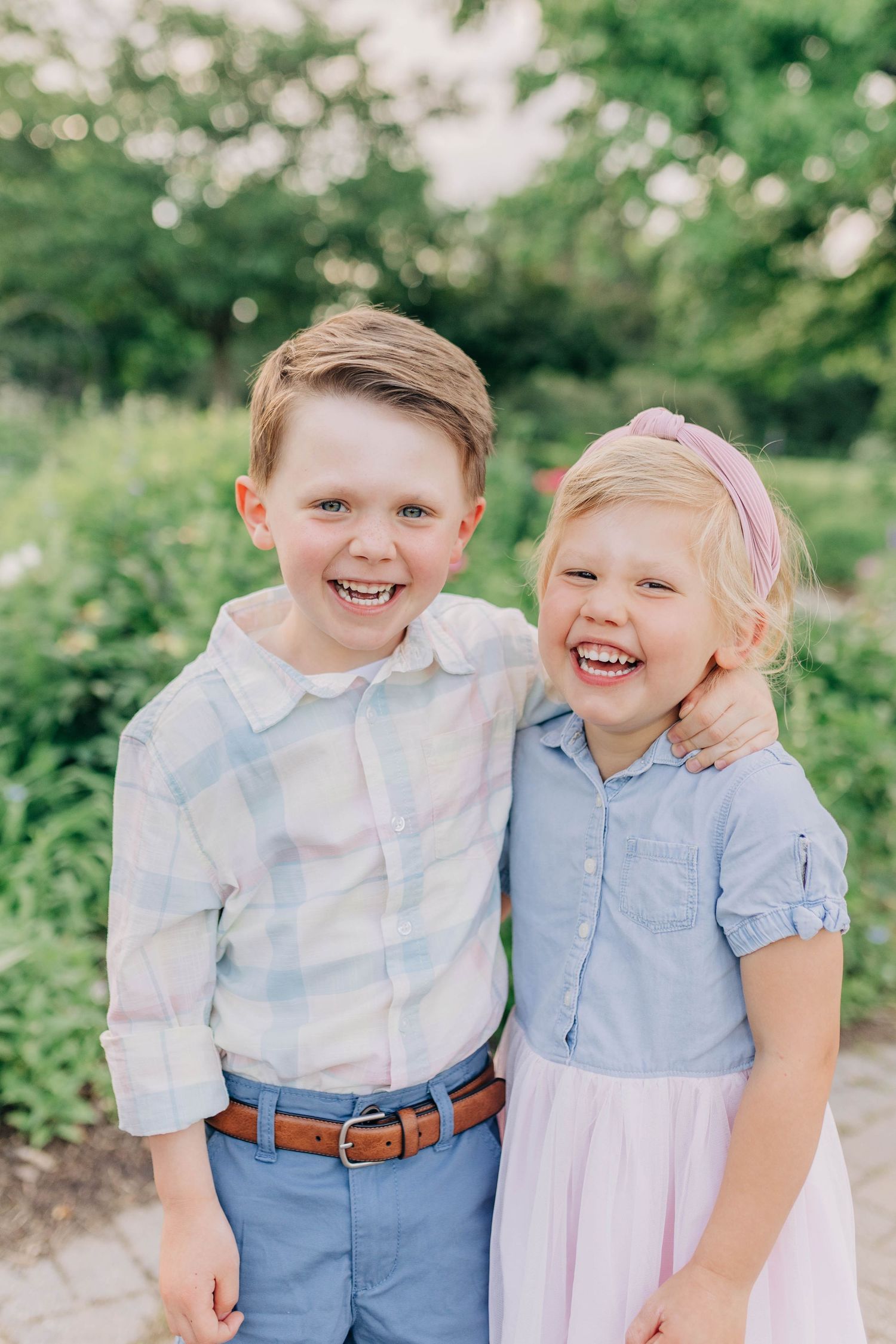 Sweet candid shots of children sharing laughter and hugs in a summer garden.