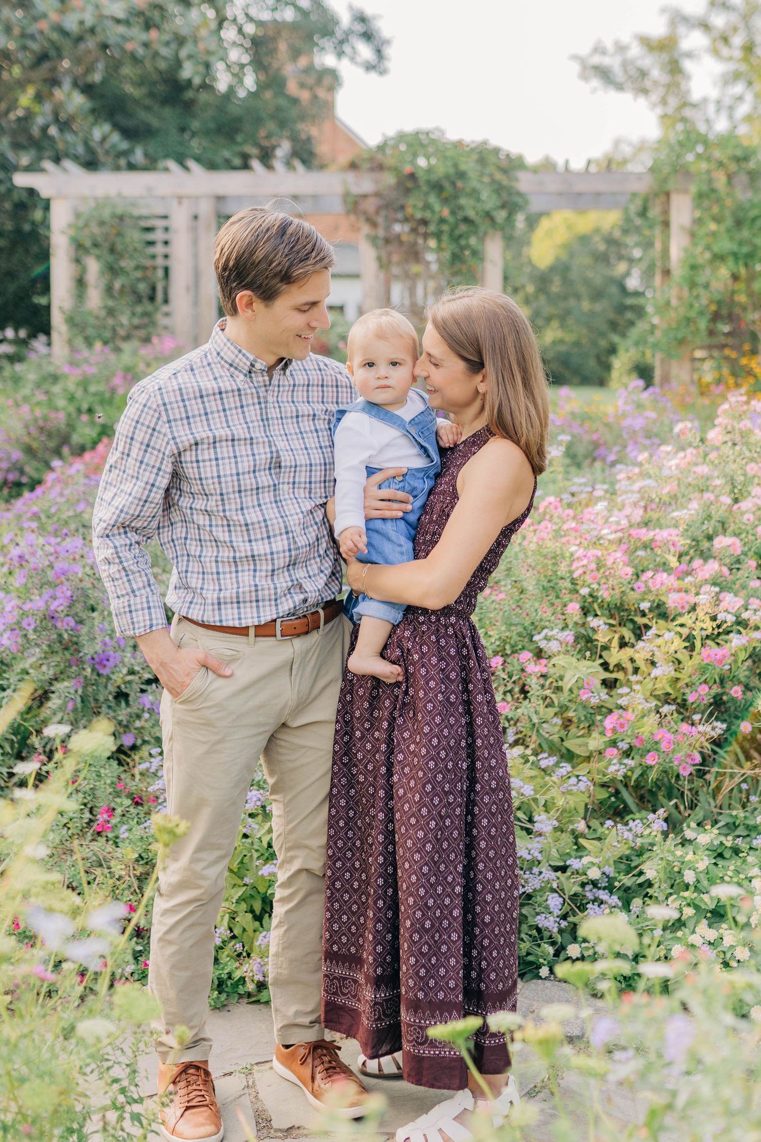 Family enjoying a tender moment together in a blooming flower garden.