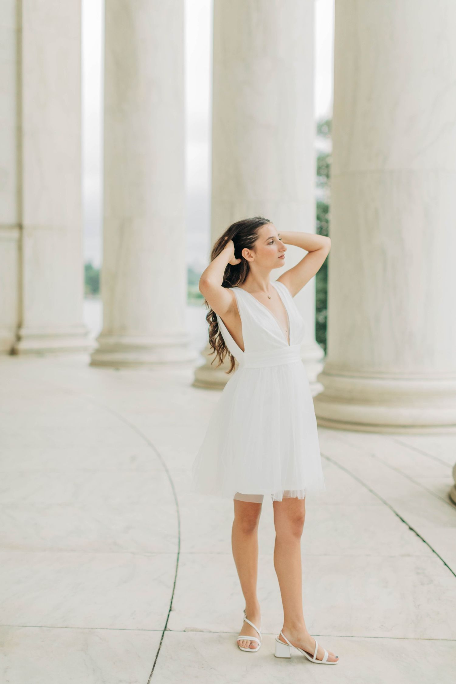 Artistic poses captured between white classical columns in natural light.