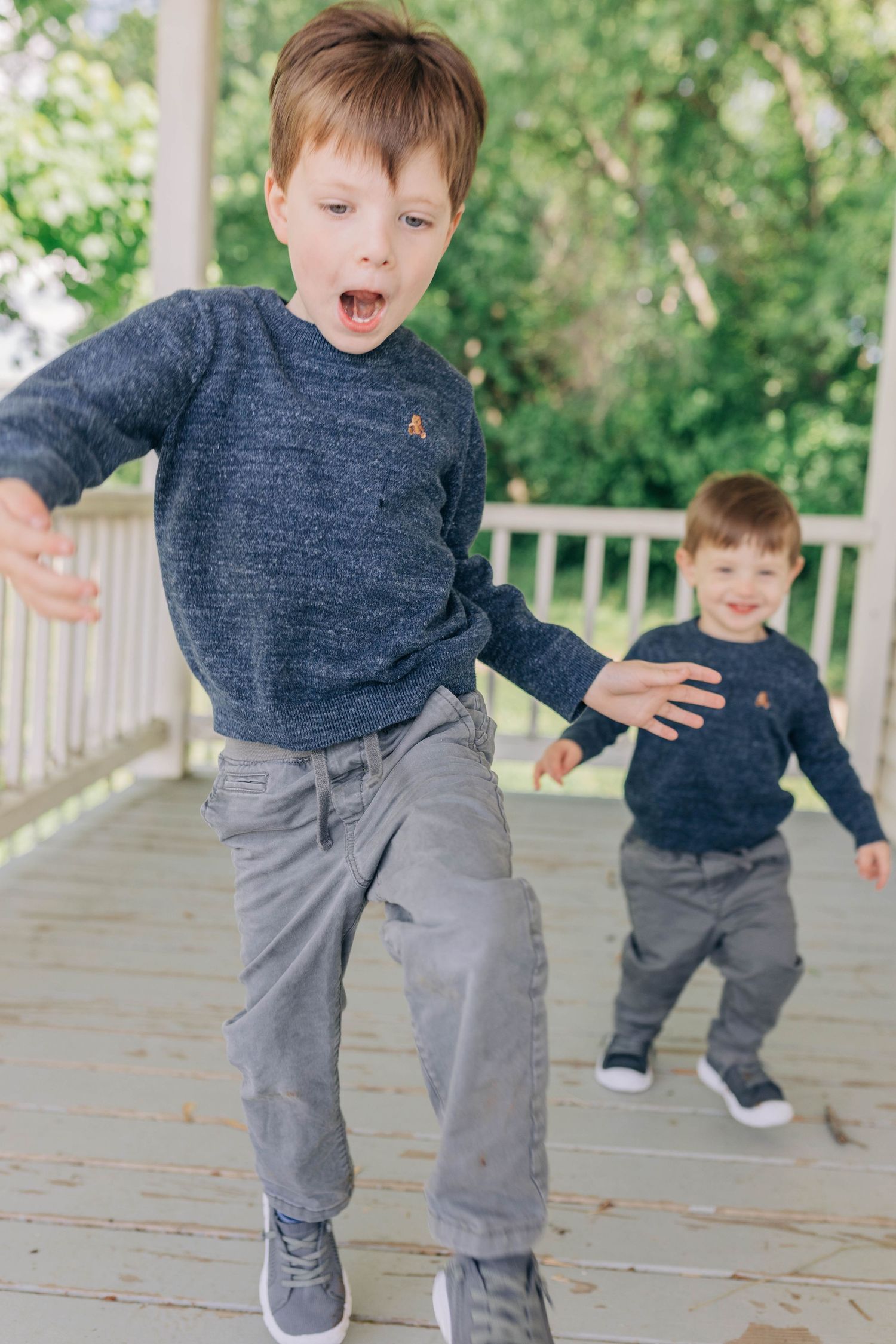 Playful sequence of children jumping and running on a wooden deck outdoors.
