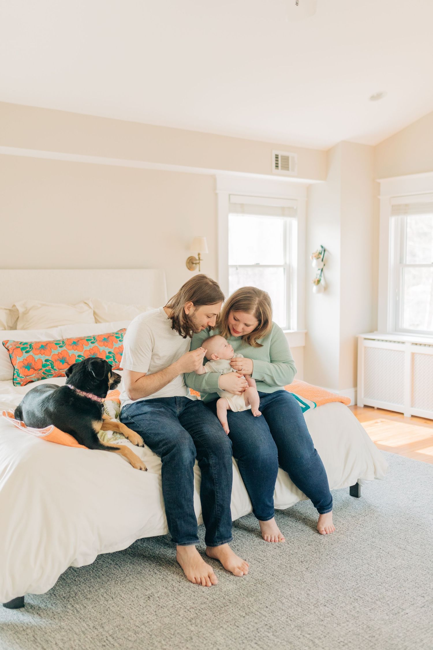 Playful family interaction sequence on white bed with grey carpet.