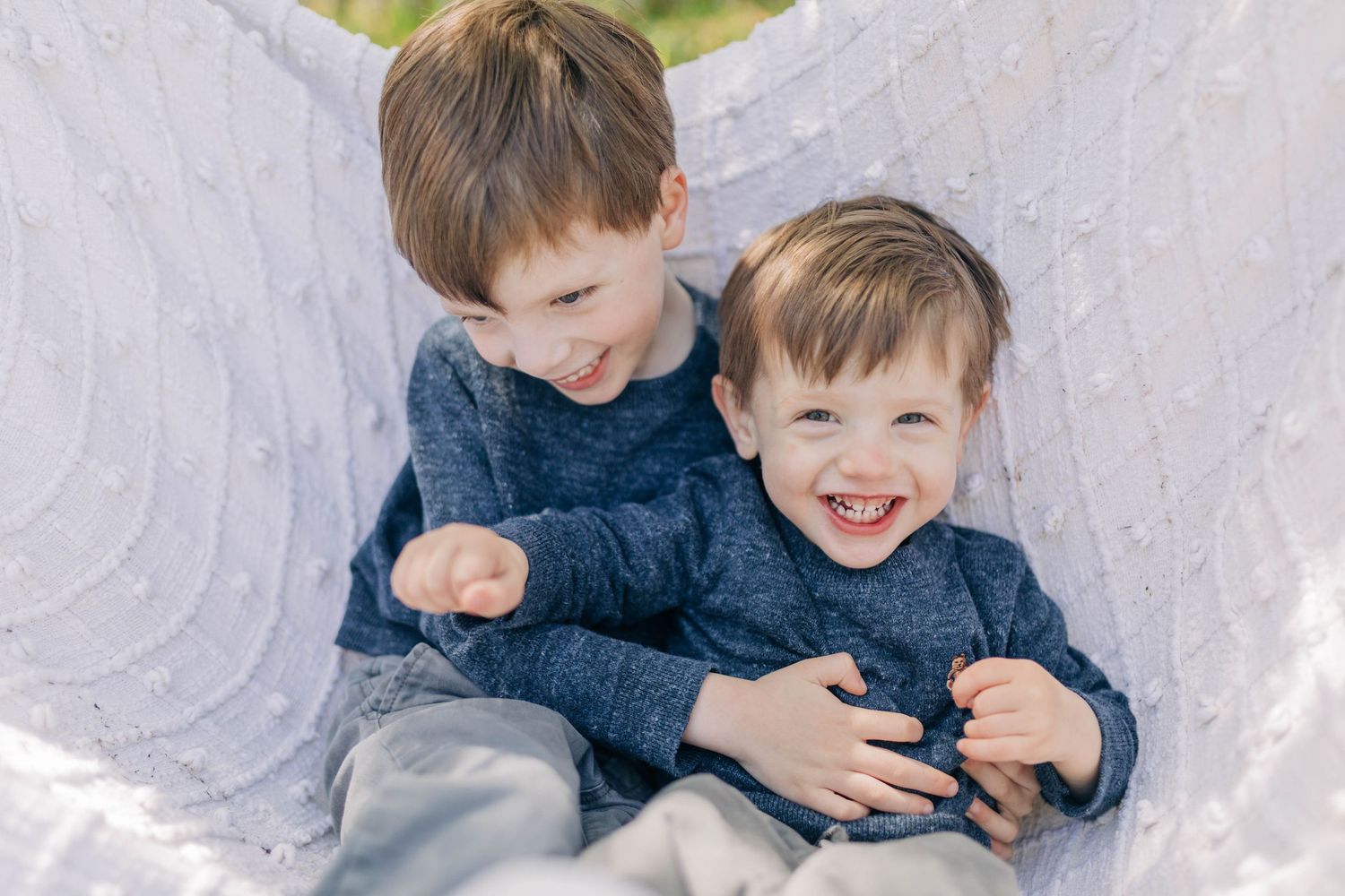 Sweet candid moments of children playing and laughing together against a light background.