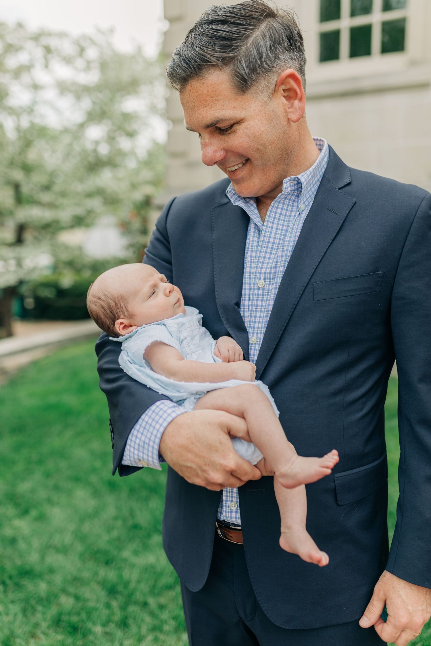 Gentle outdoor portrait series showing precious moments with a tiny baby in light blue clothing.