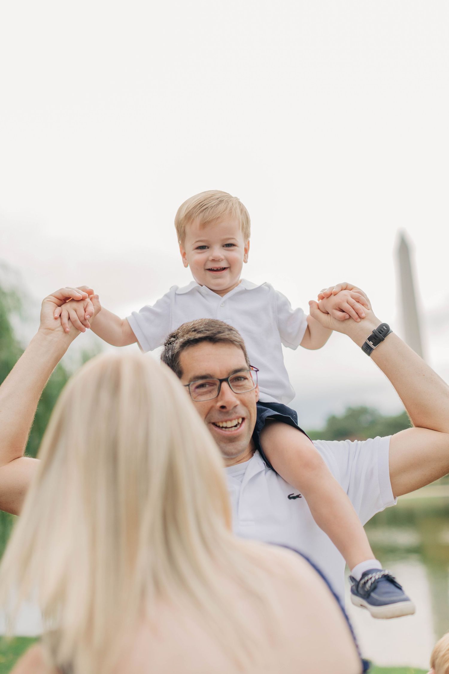 A playful moment captured at the National Mall with the Washington Monument visible in the distance.