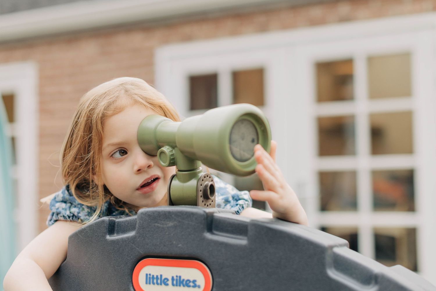A playful moment outdoors with a toy telescope on a sunny day.