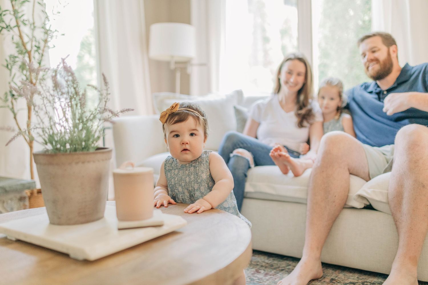 Candid family interaction in a bright, modern living room with plants.