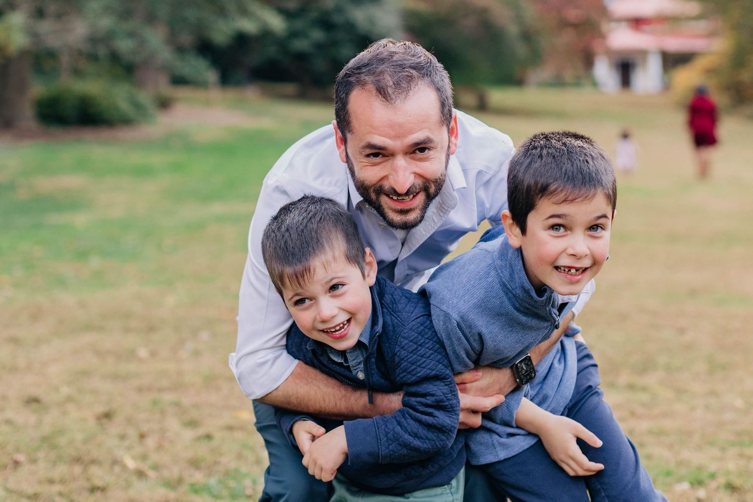 Playful family moment captured outdoors with joyful expressions.