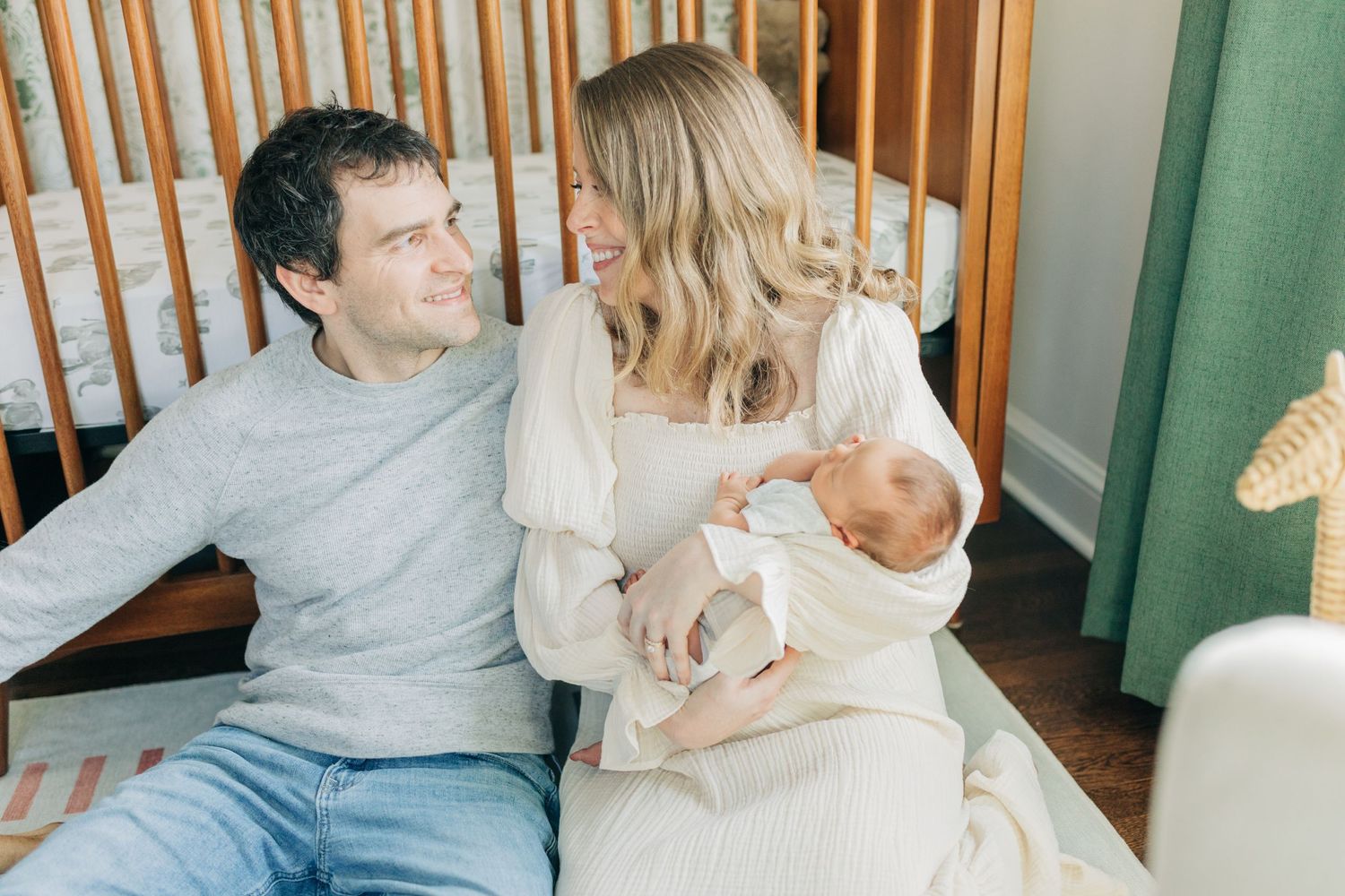 Intimate family portraits in modern nursery with sage green accents.