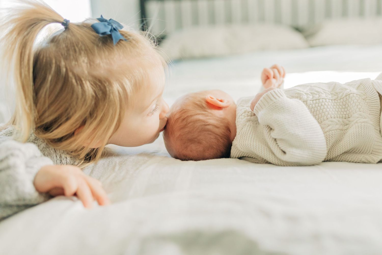 A tender moment between siblings sharing time together on a bed.