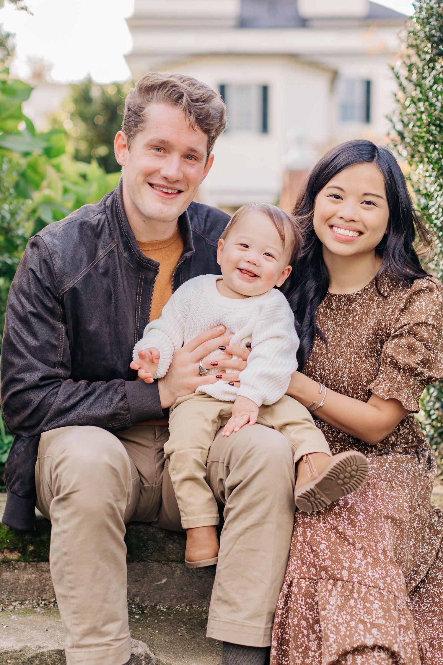 Family of three sharing joyful moments together during outdoor portrait session.