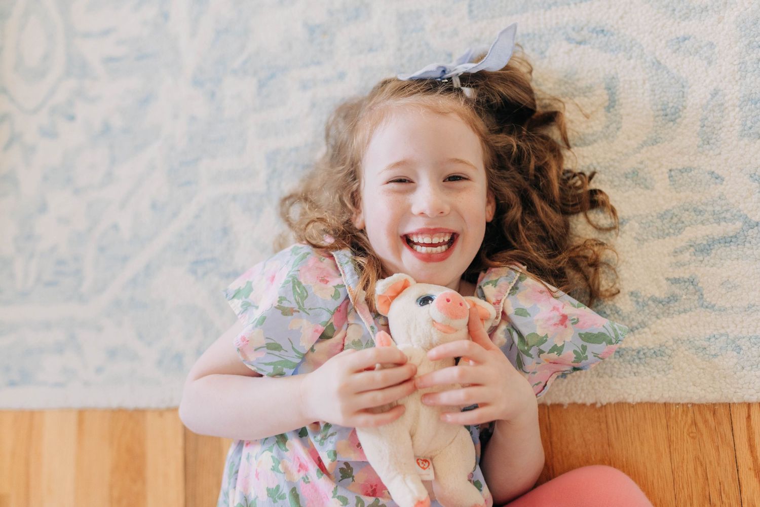 Children lying on white bedding while playing with toys.