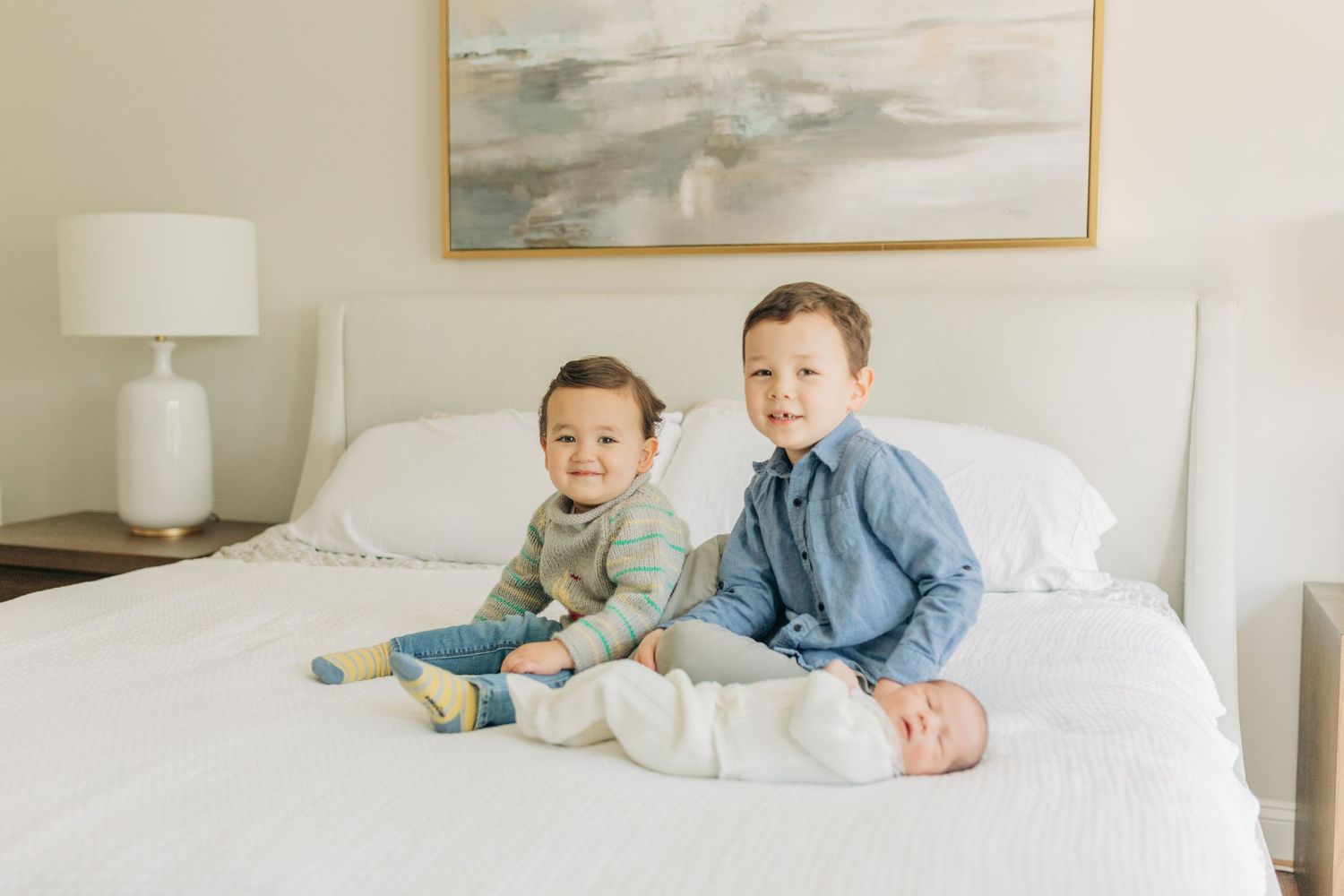 Children sharing special moments together on a white bed with modern decor.