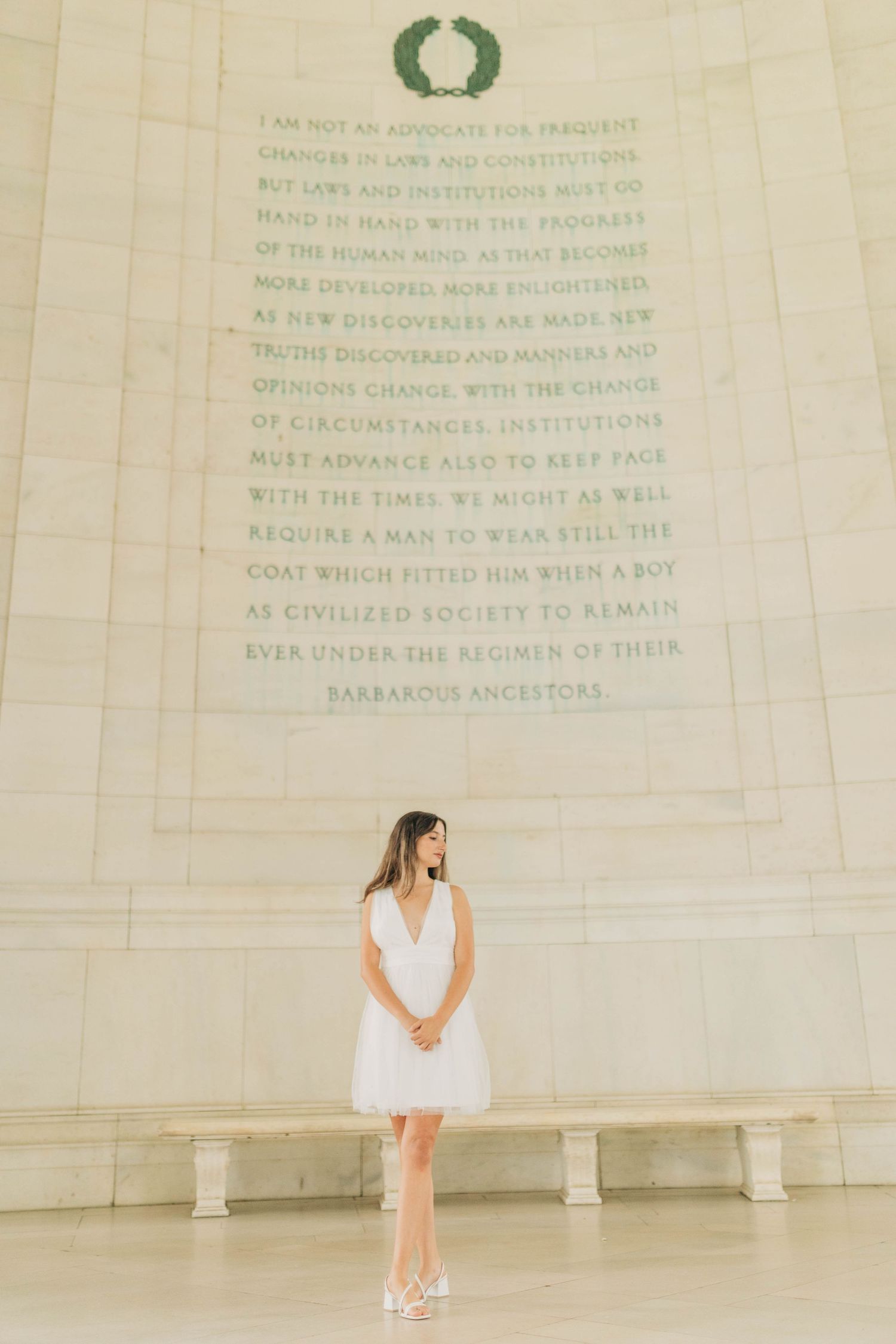 Minimalist portrait session at a memorial with engraved text visible on the wall.