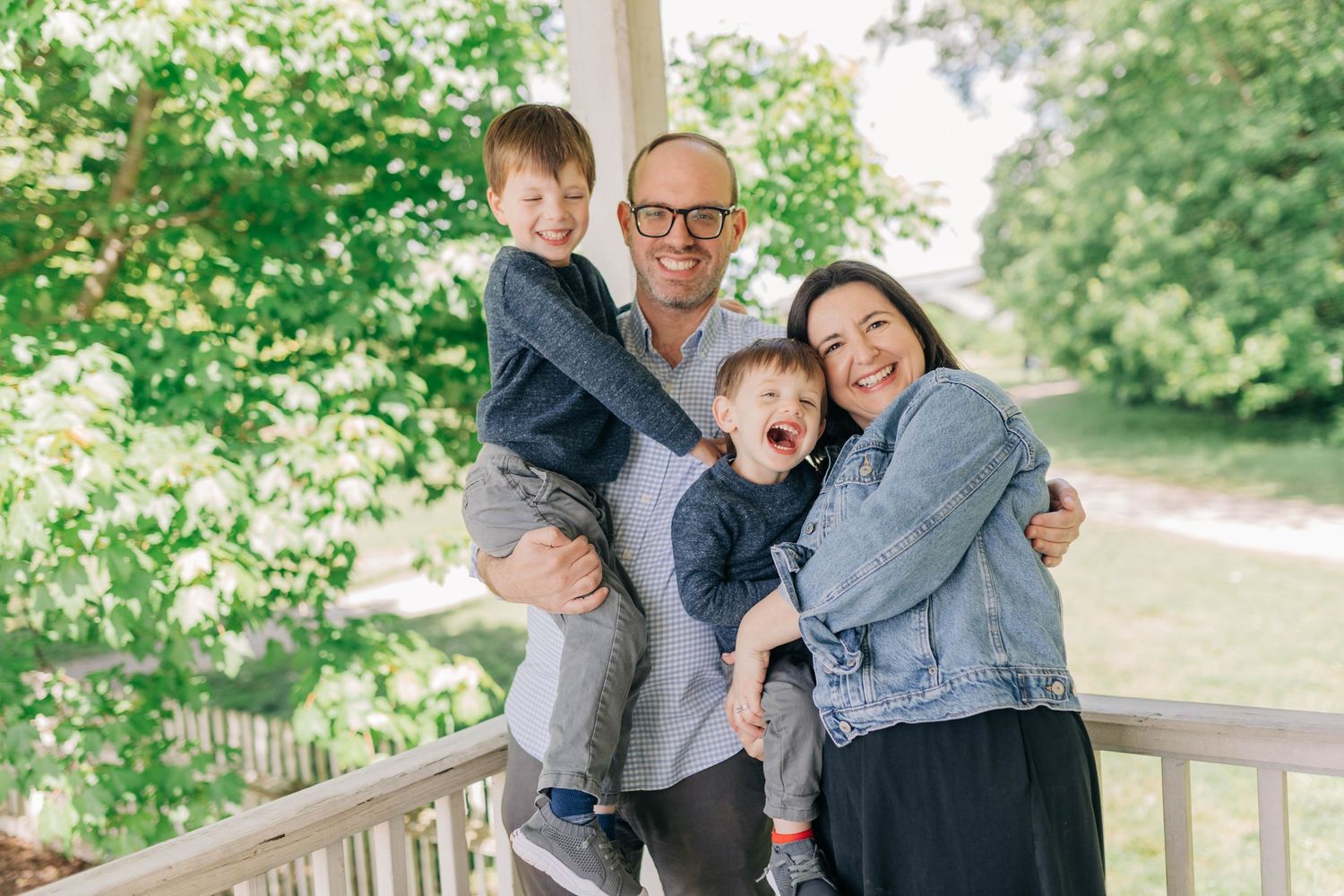 Family sharing joyful moments together on a wooden deck surrounded by greenery.