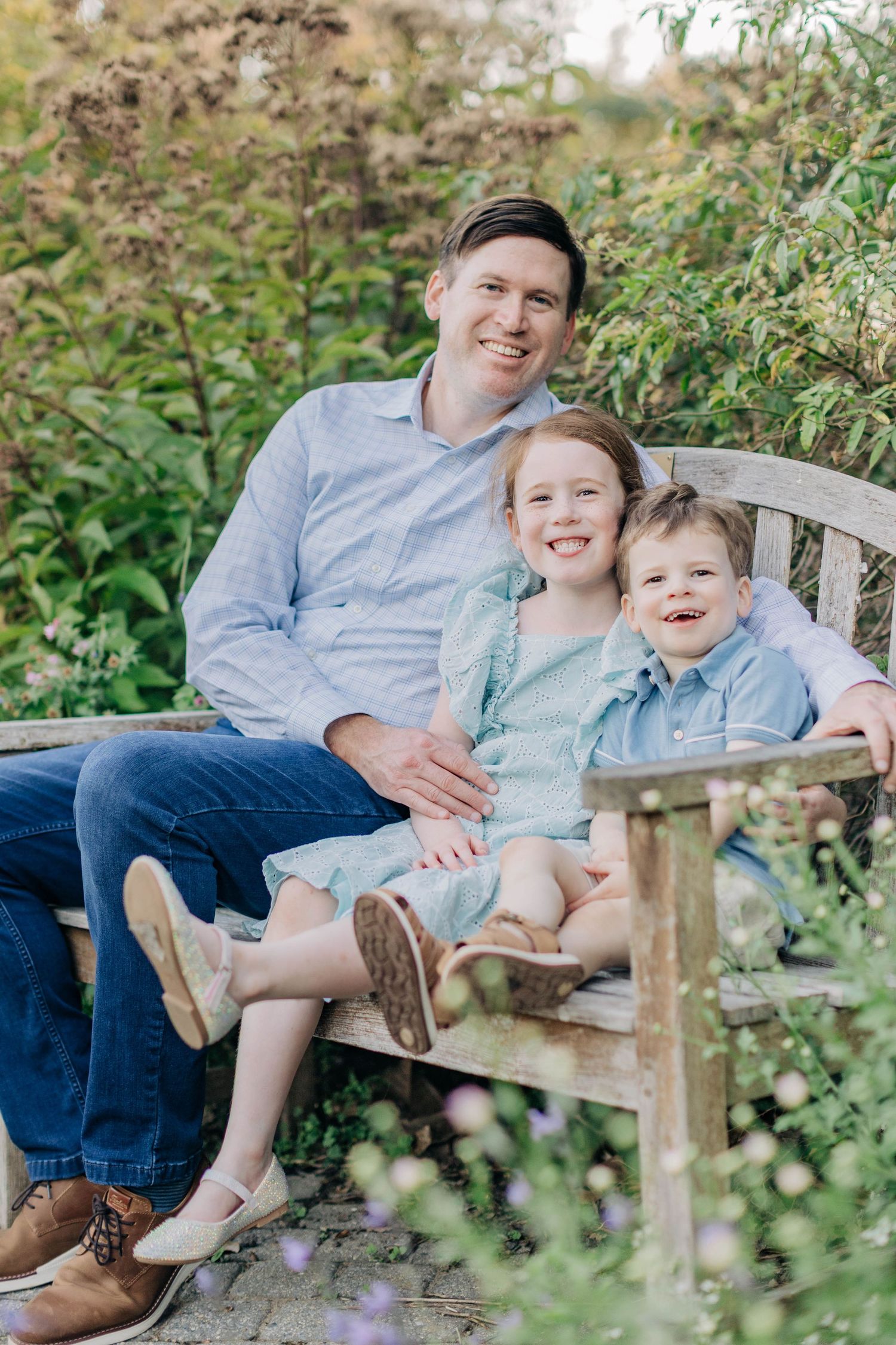 Family members sharing a happy moment while sitting together on a wooden garden bench.