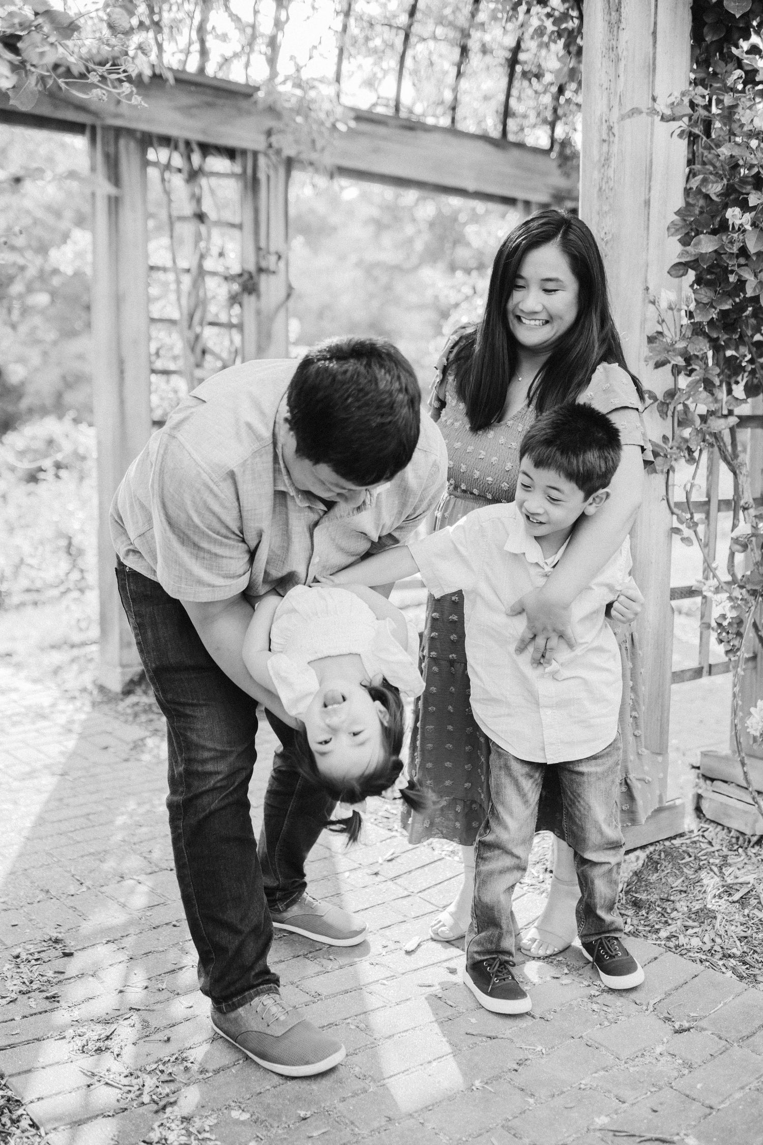 Black and white series showing a tender moment of parent and child playing together outdoors.