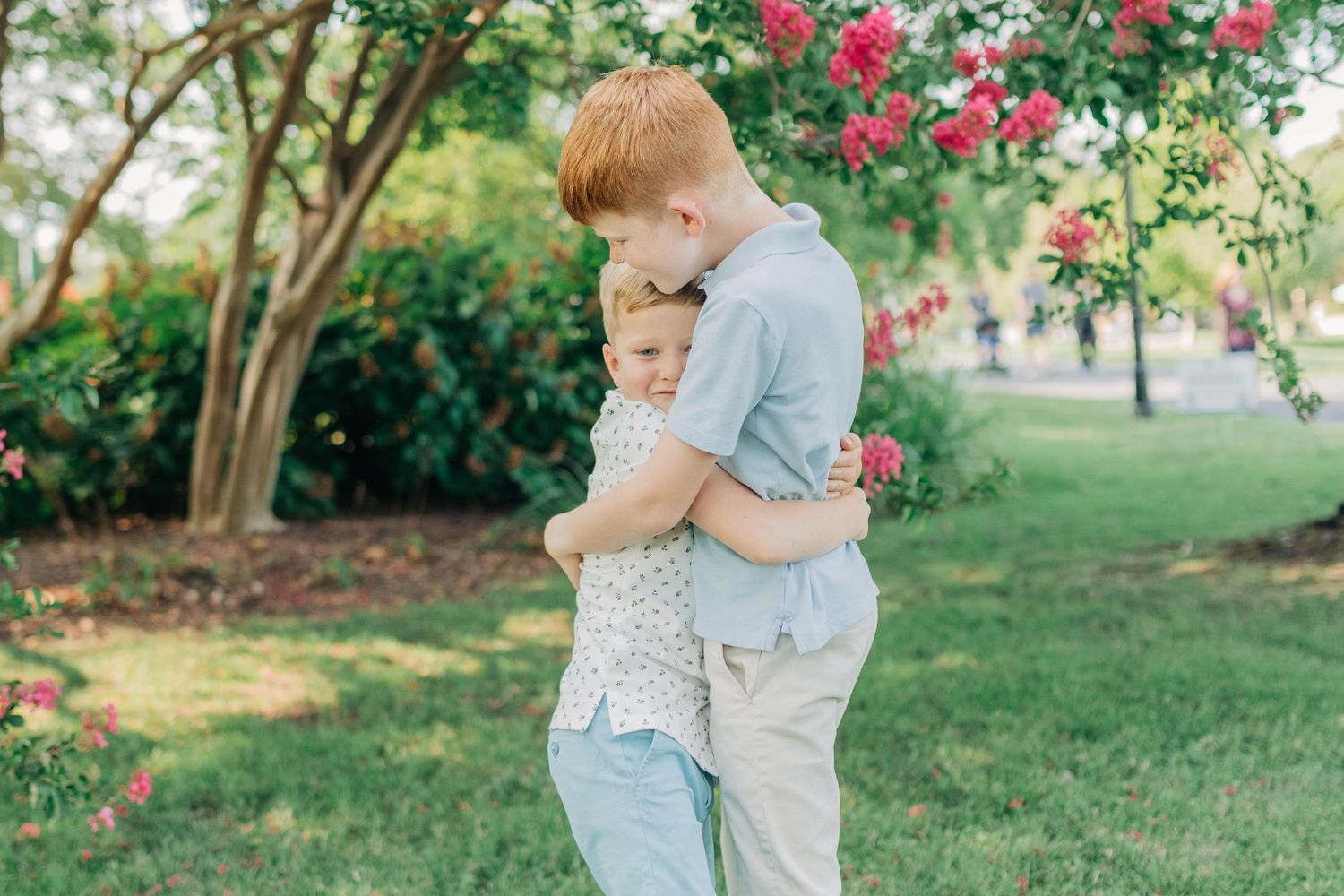 Candid moments of children playing in a garden with blooming crepe myrtle trees.