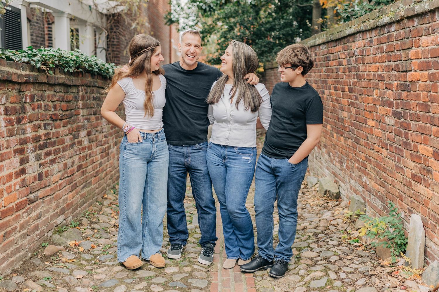 Casual family photos taken along a brick walkway with climbing vines.