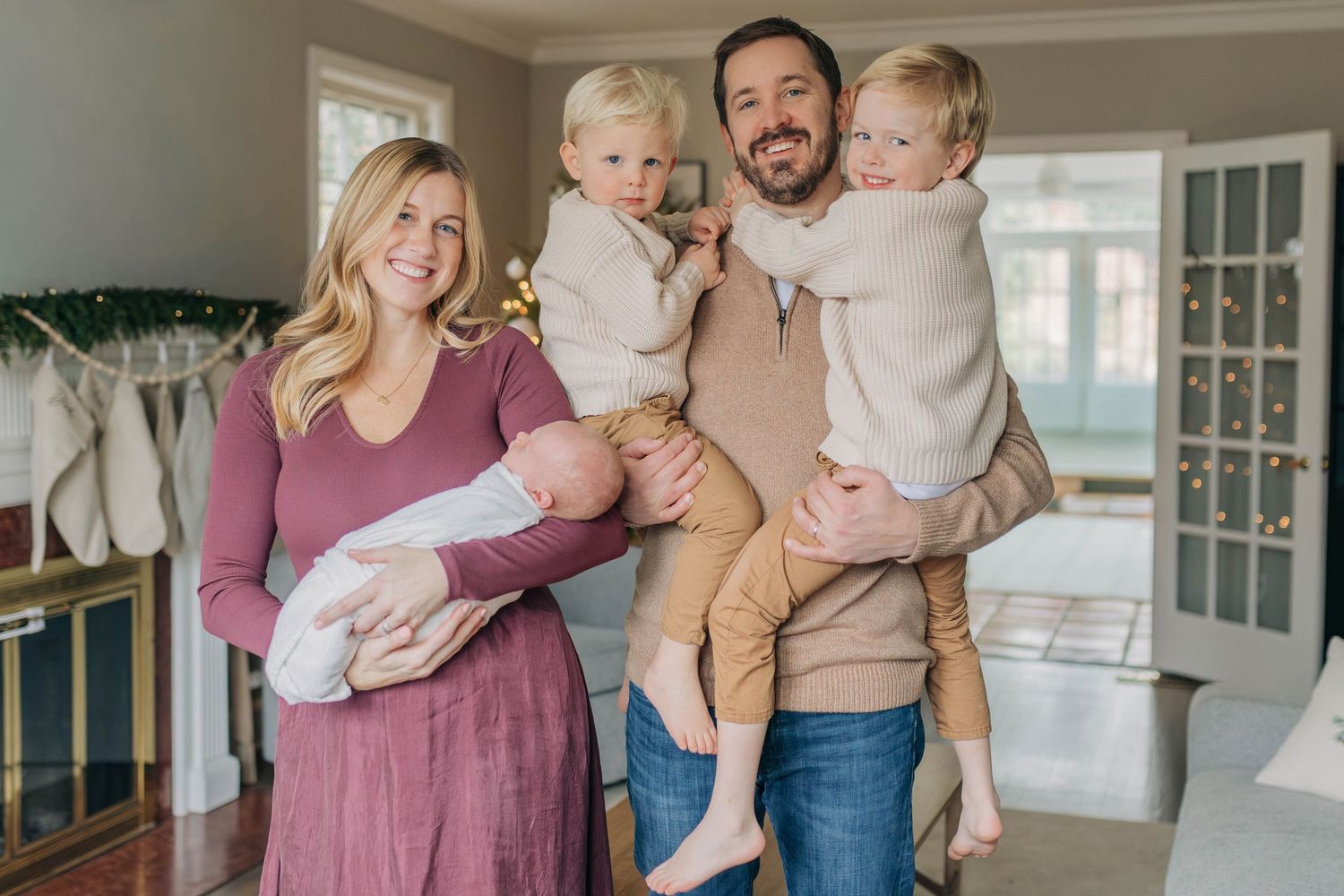 A family poses together in their living room decorated with holiday greenery.
