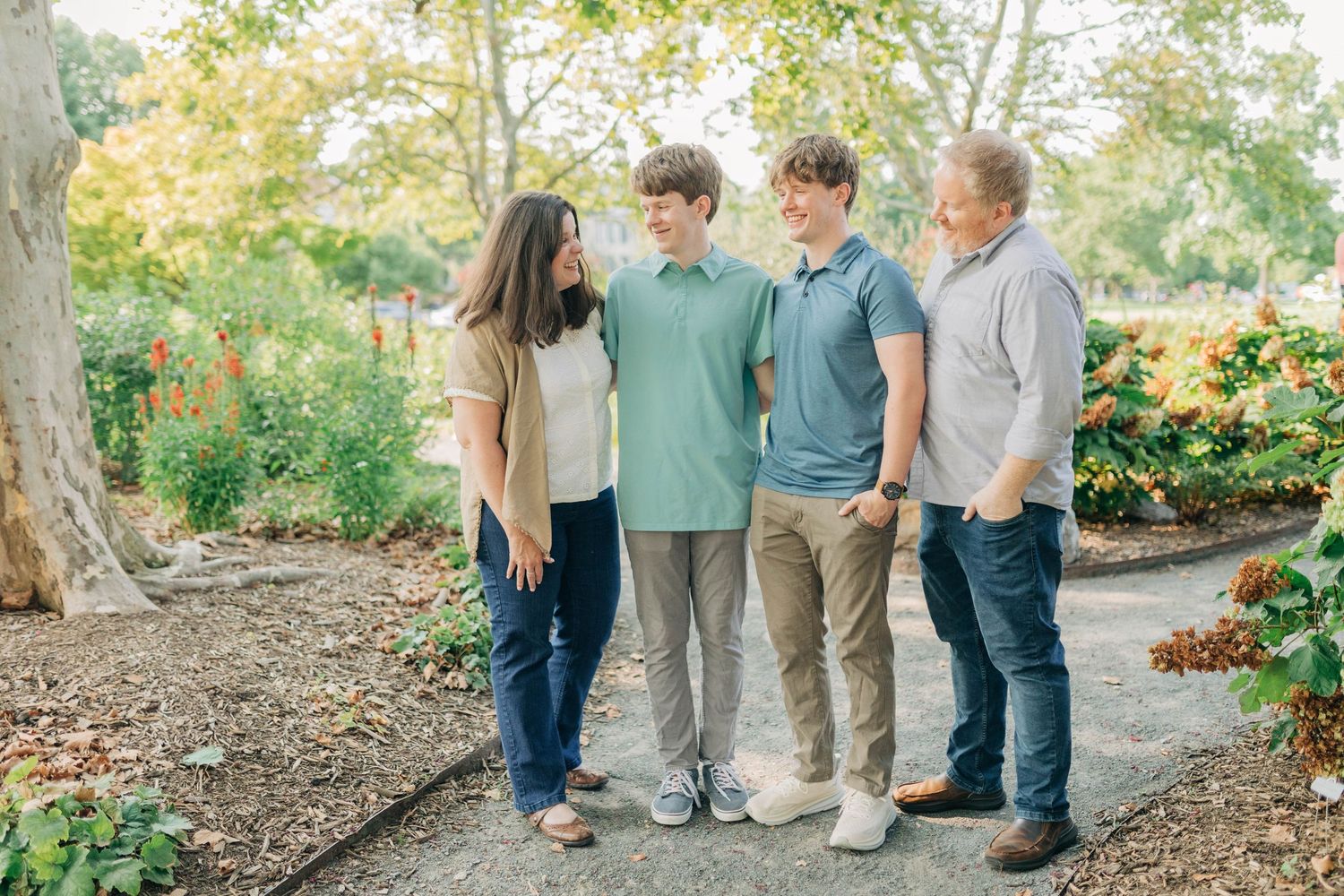 Group portrait of family members standing together outdoors in casual attire.