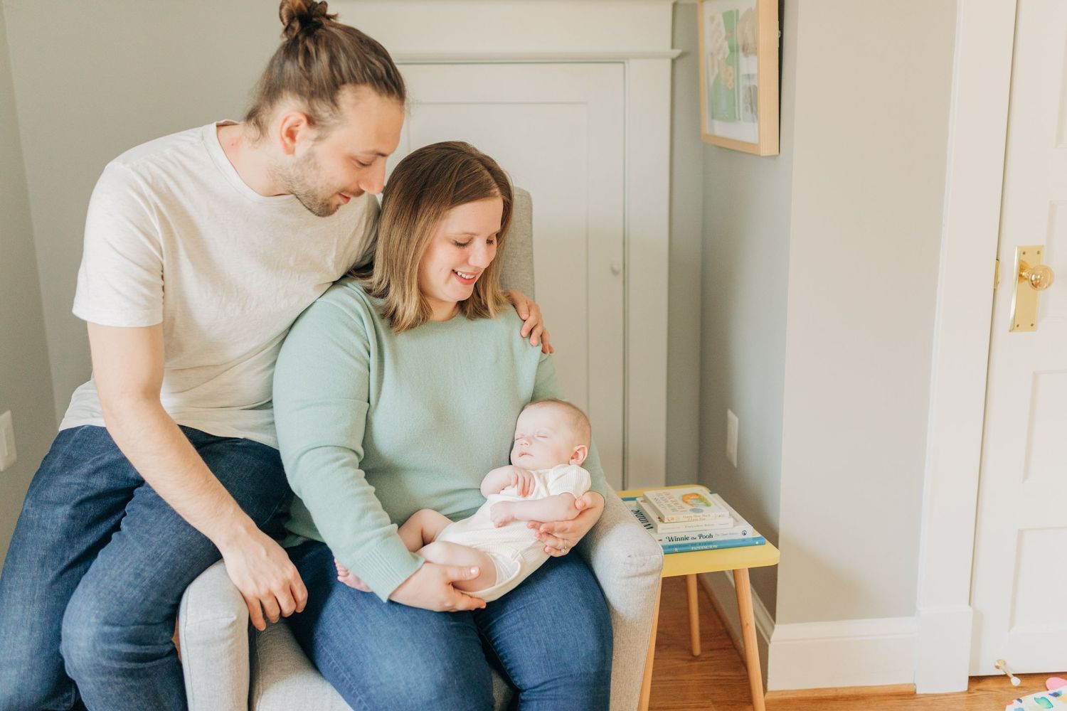 Family enjoying tender moments with their baby in a bright modern bedroom.