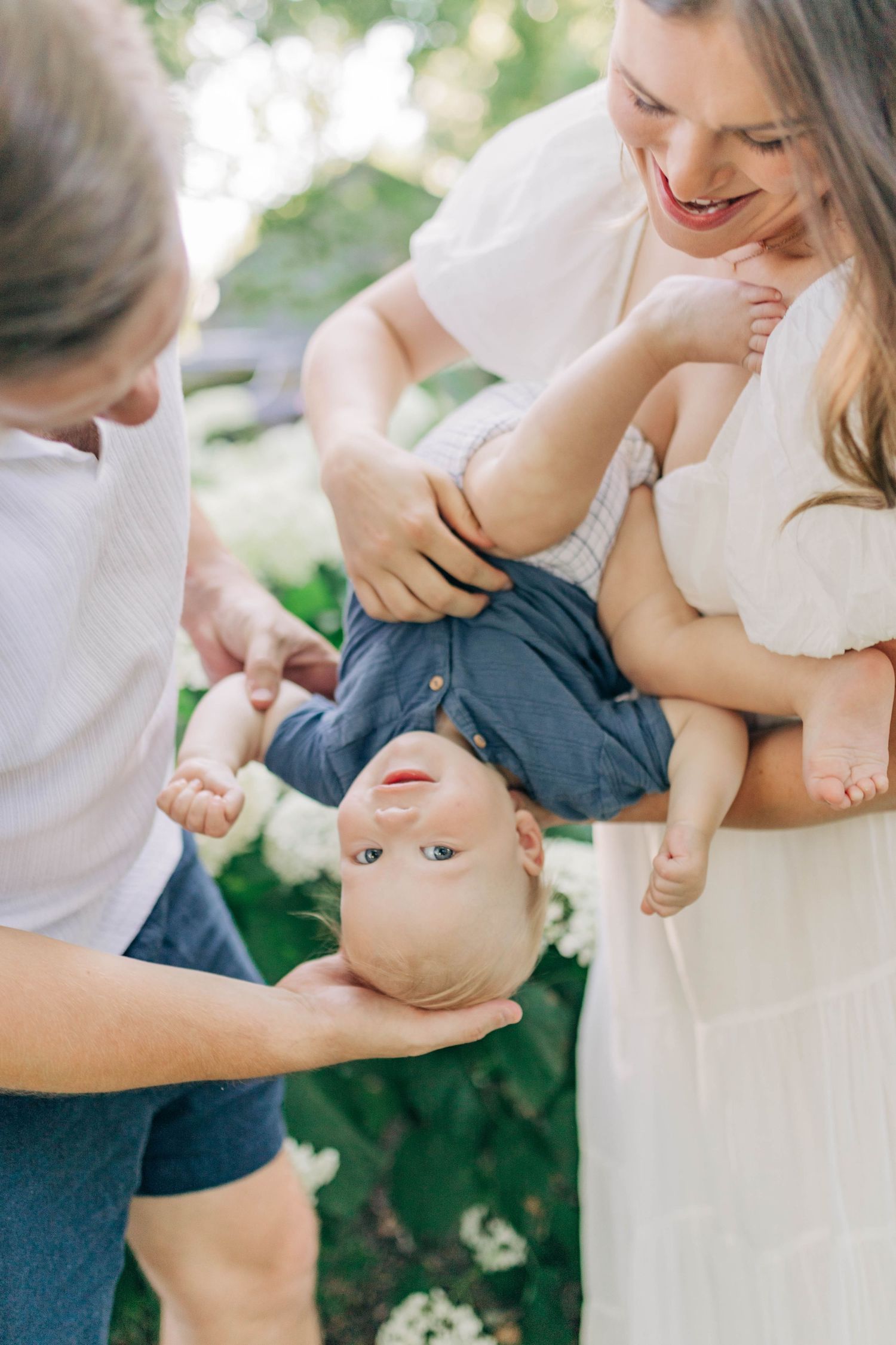 Intimate family portraits showing playful interactions in a garden setting.
