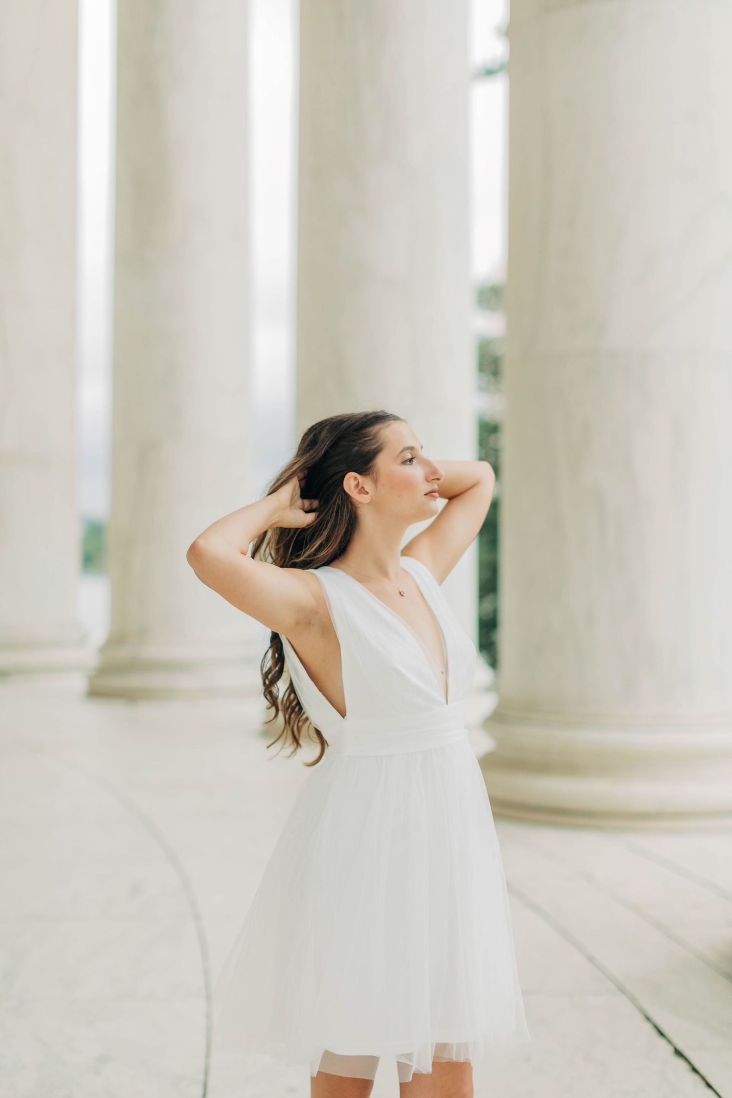 Dynamic poses photographed between white columns showing movement and joy.