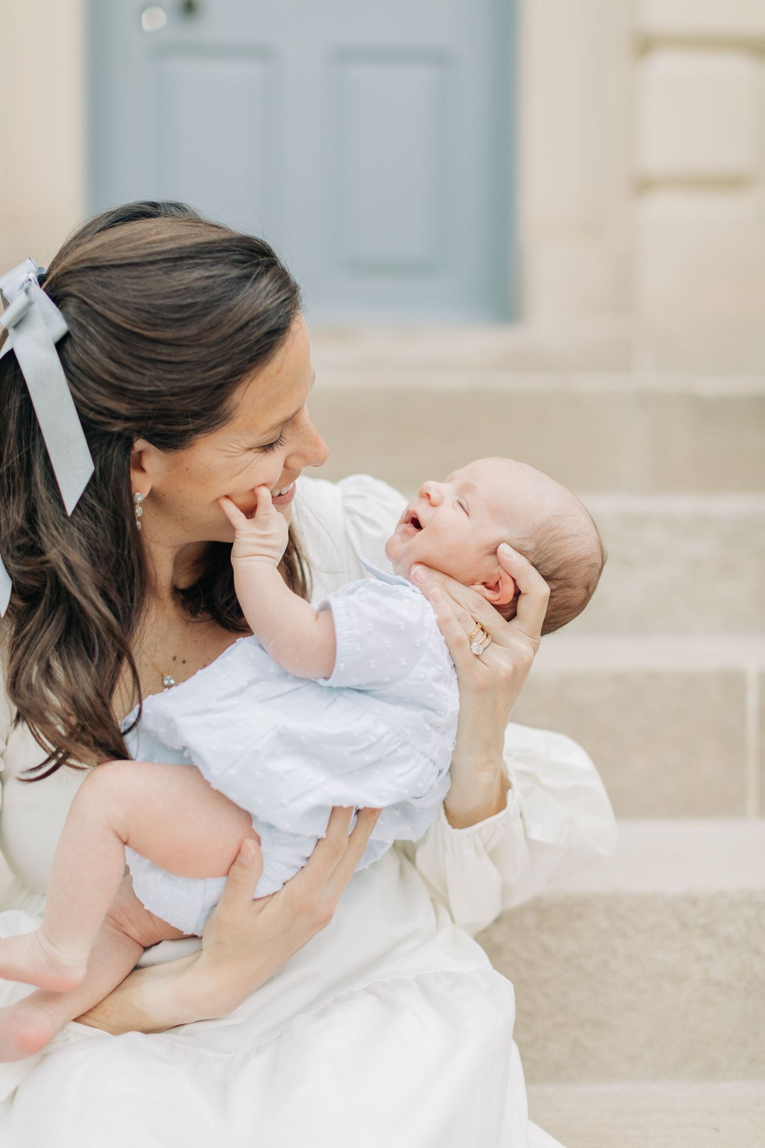 Mother and baby share sweet interaction on stone staircase.