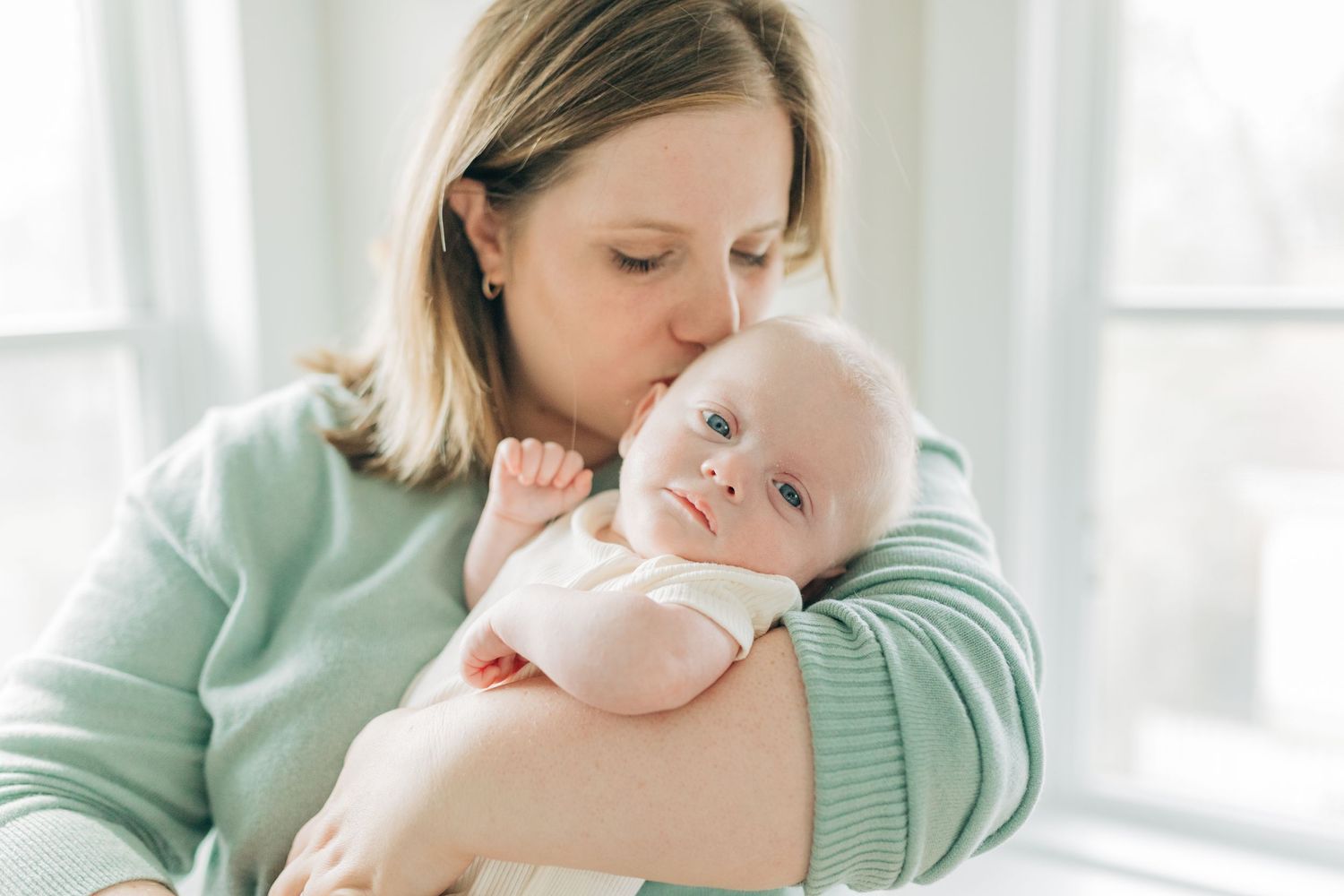 Intimate family bonding moments in bright white room.