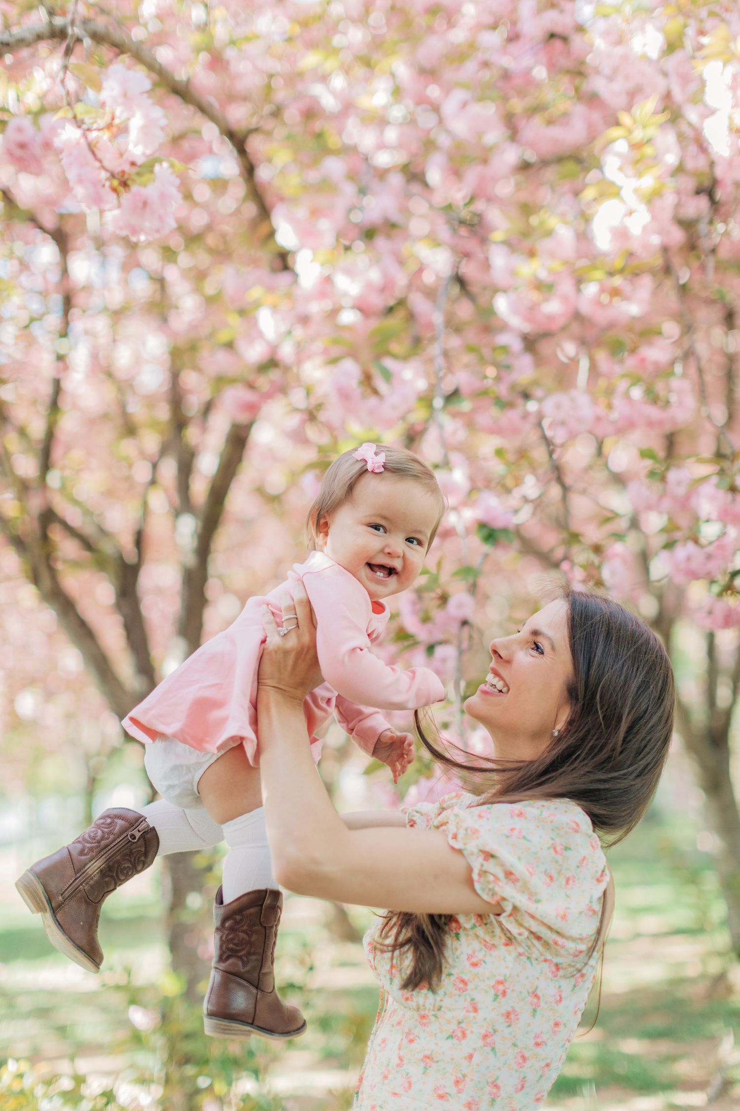 A joyful moment captured while playing under blooming cherry trees in spring.