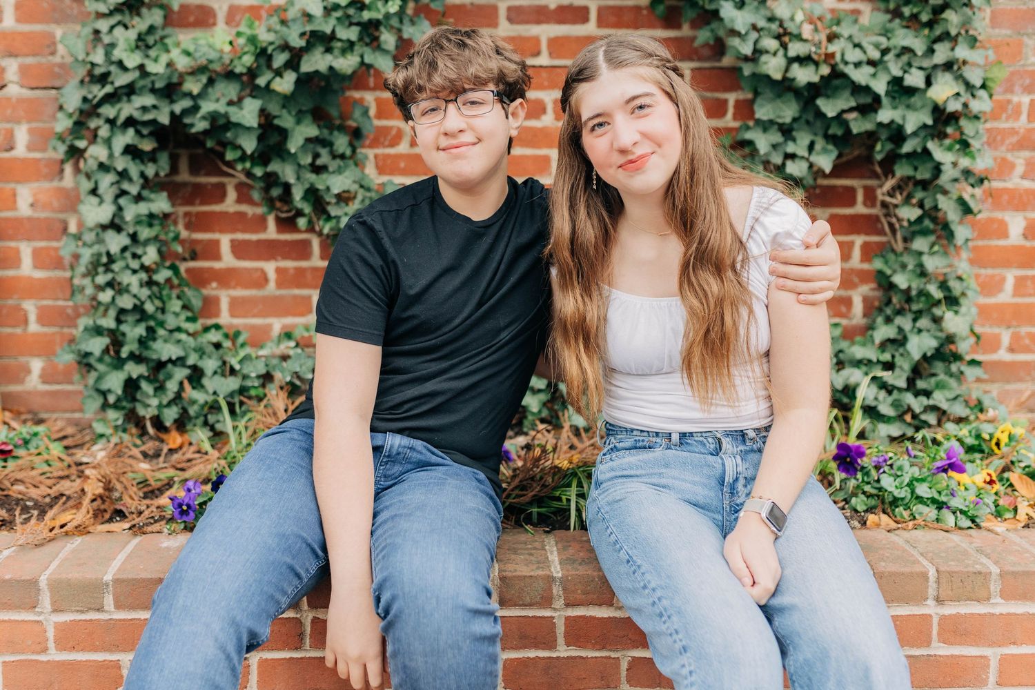 Relaxed family portraits against a vintage brick wall with green ivy.