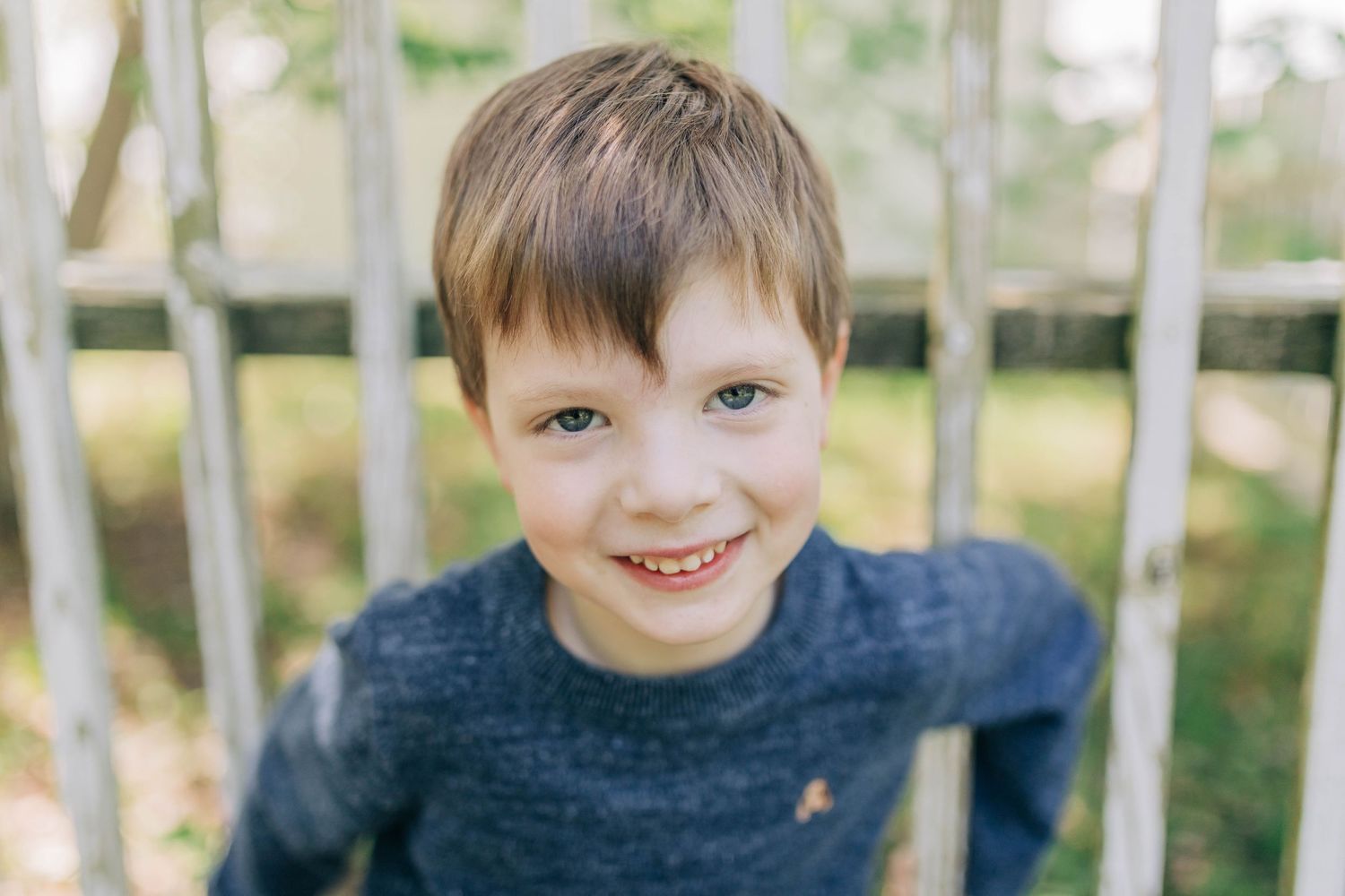 Close-up portraits of children laughing and playing in a natural outdoor setting.