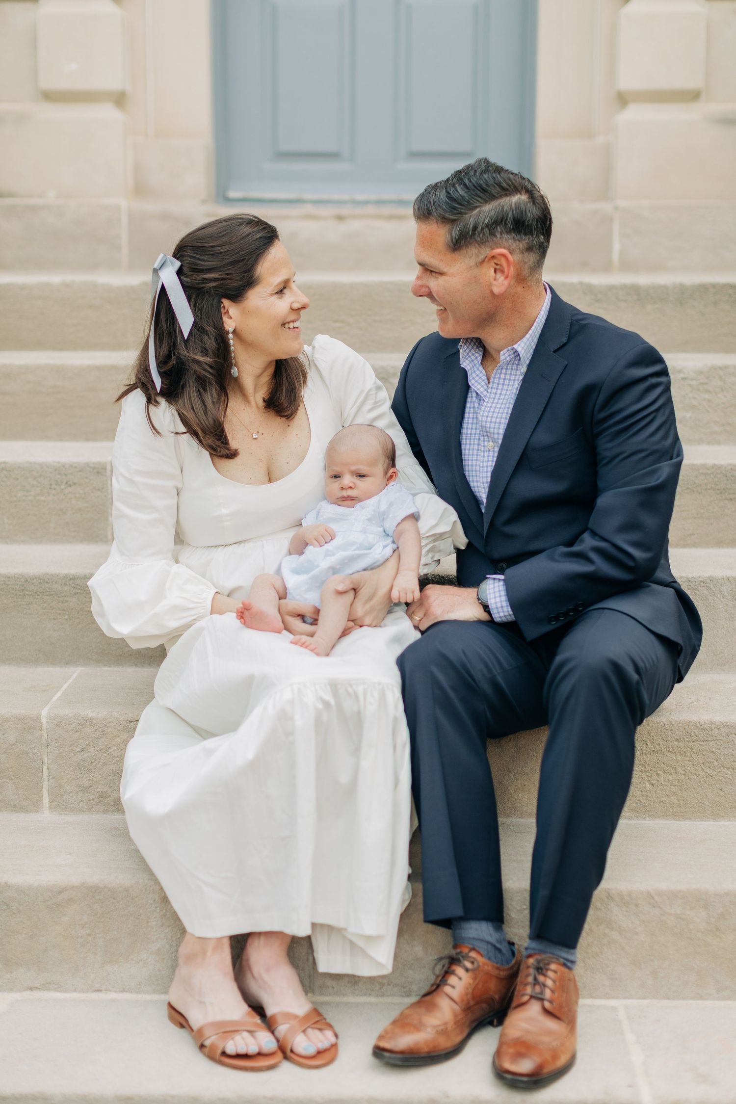 Family shares intimate moment together on stone staircase.