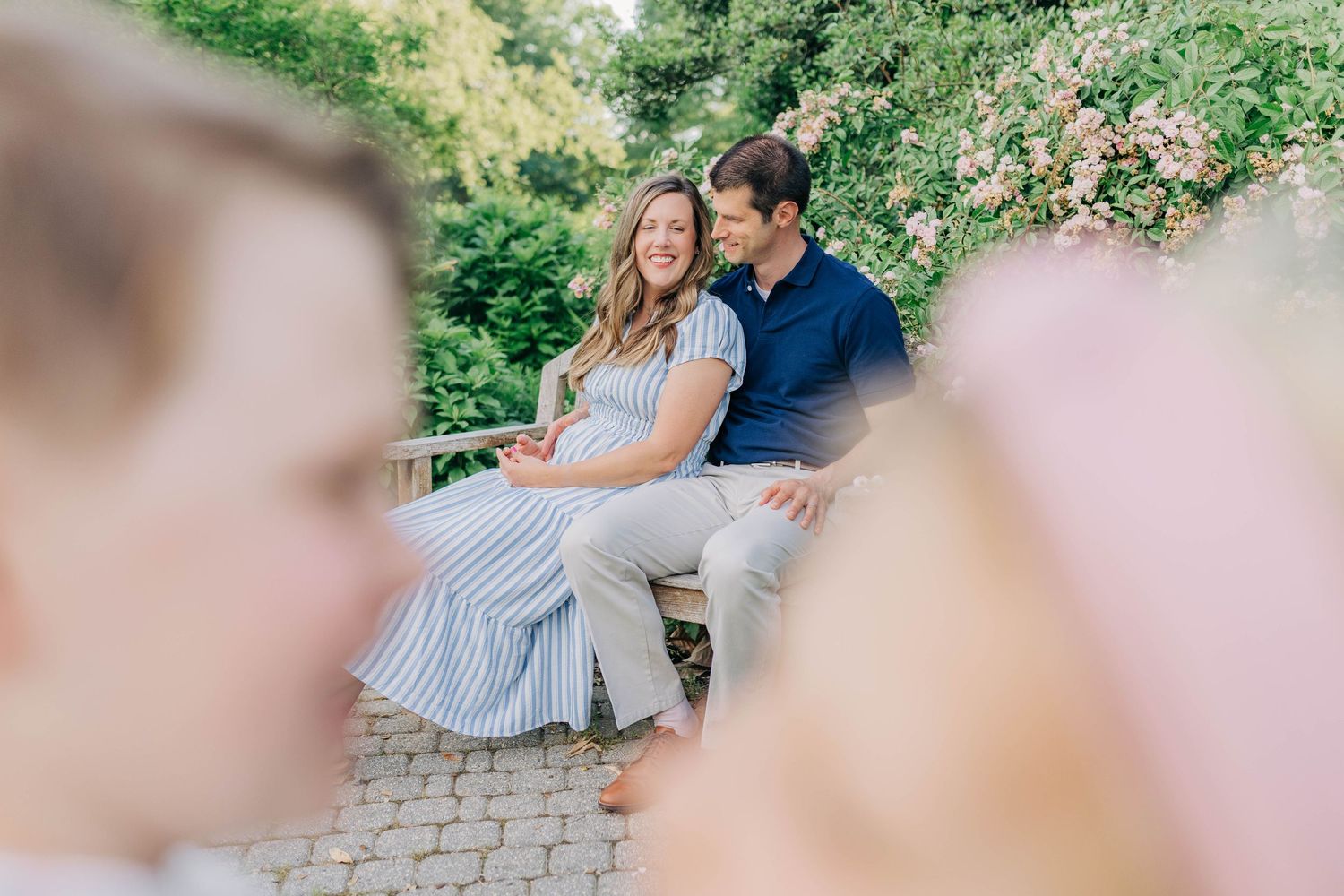 Soft focus family photography capturing intimate moments in a garden setting.