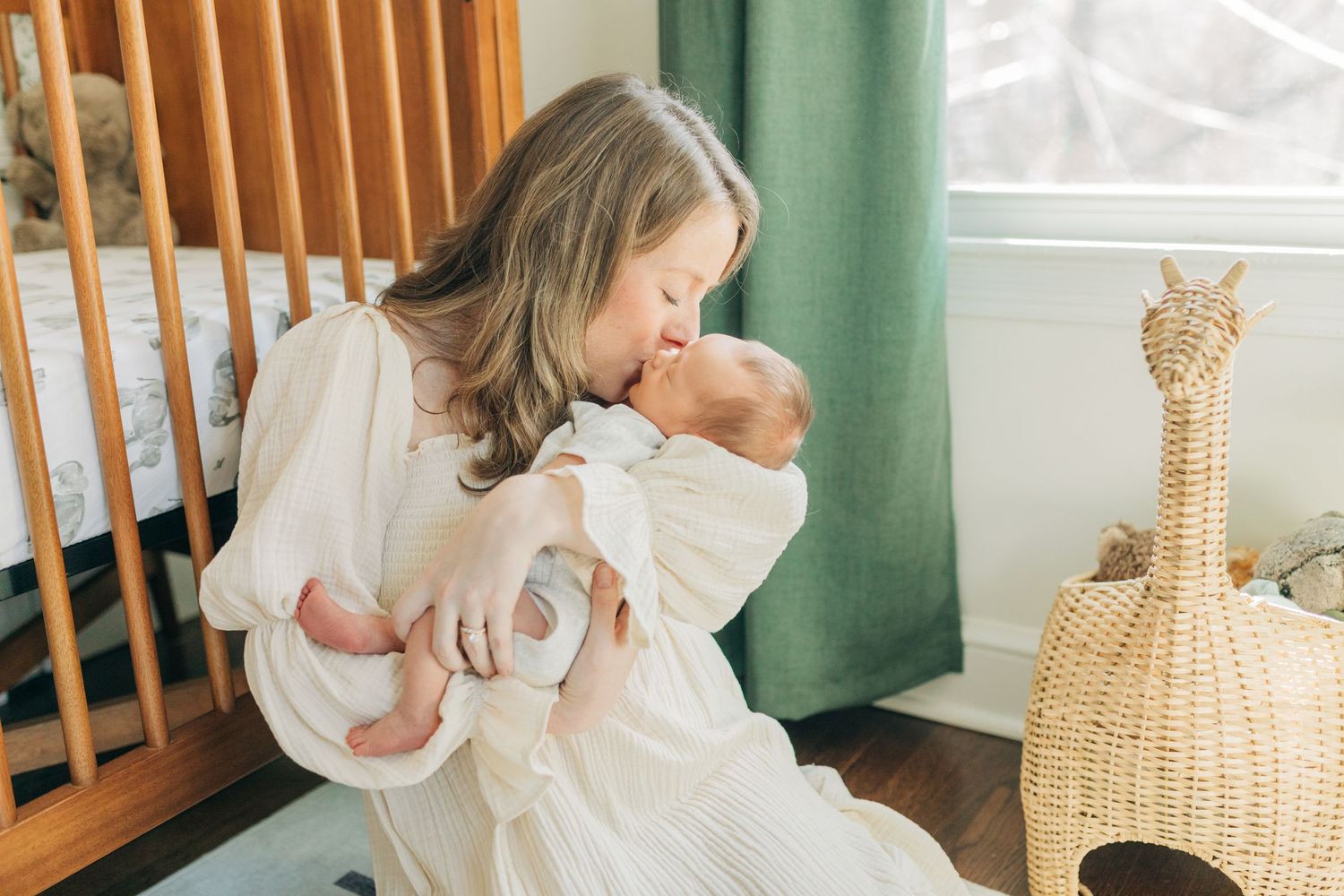 Bright nursery interior with wicker decor and green curtains during newborn photoshoot.