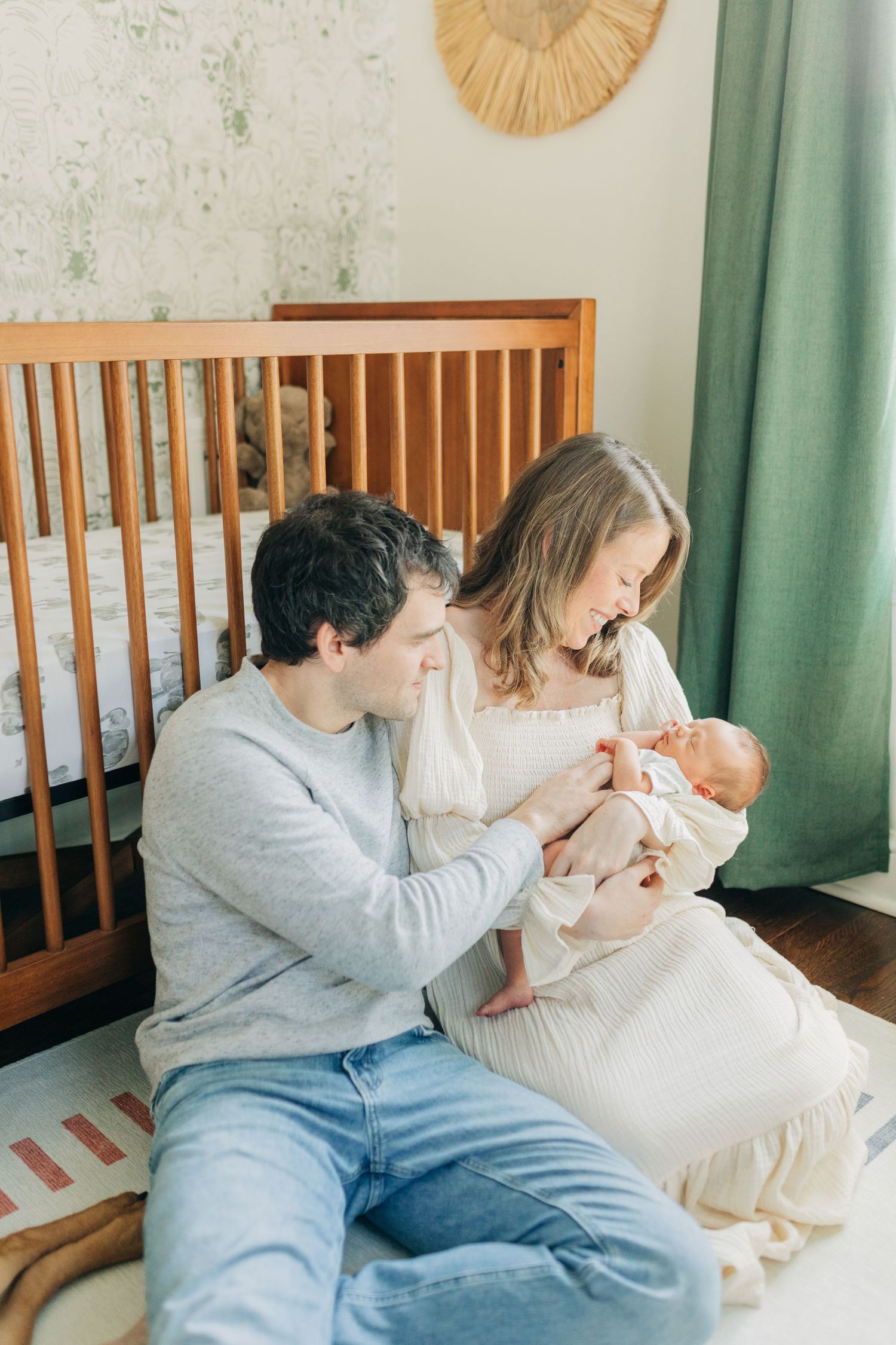 Parents lovingly interact with their newborn baby in a cozy nursery setting.