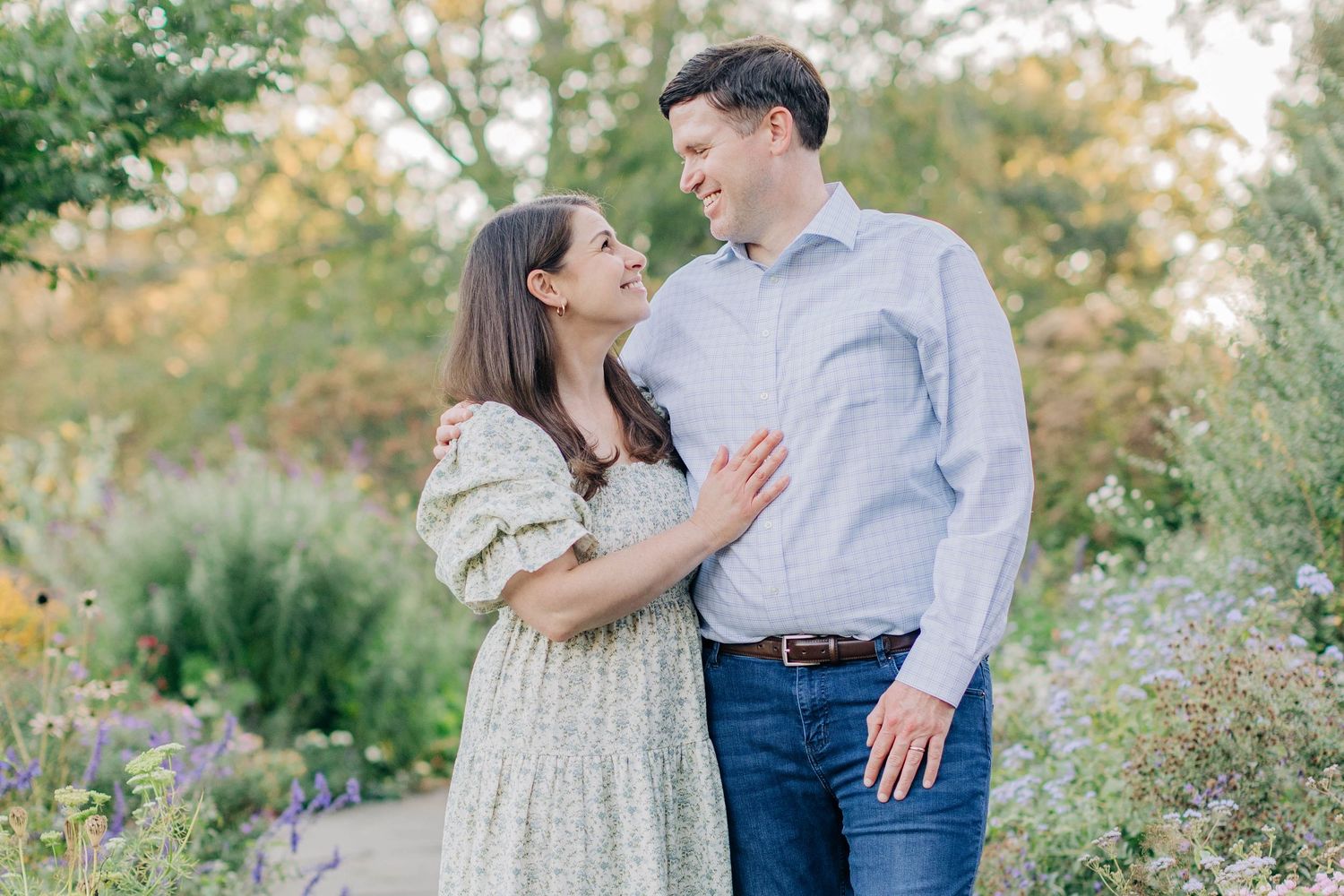 Couple sharing a joyful moment together in a garden filled with wildflowers.
