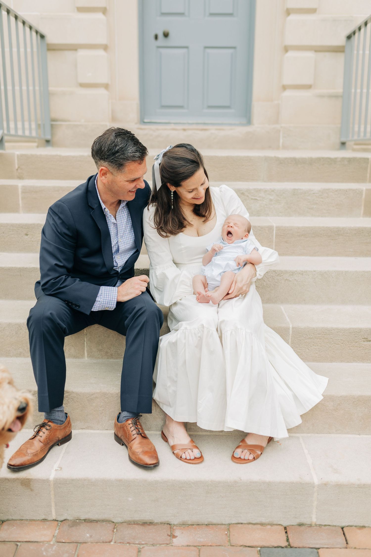 Casual family moment captured on stone steps of historic building.