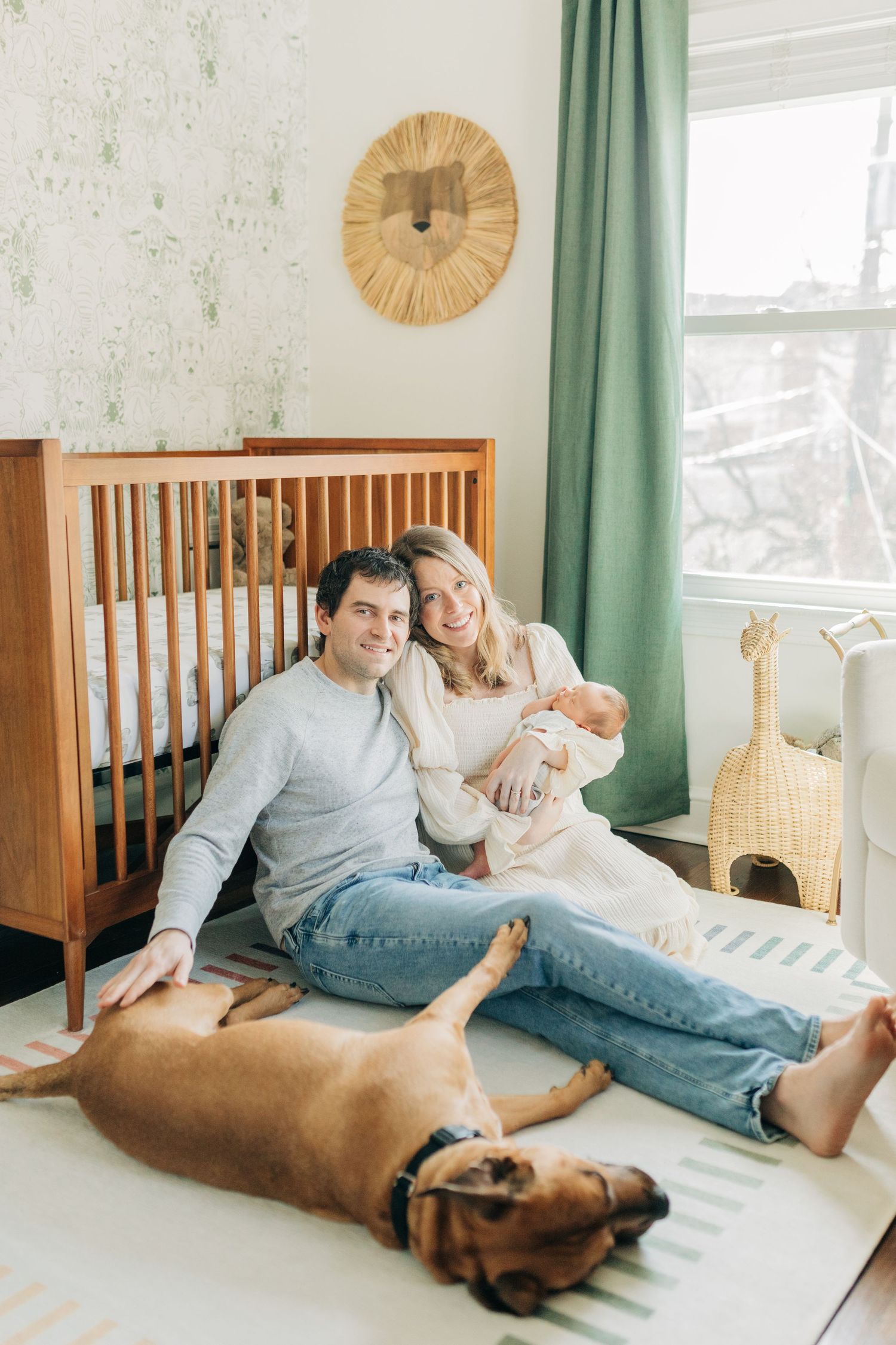 Family and pet dog sharing relaxed moments in sunlit nursery room.