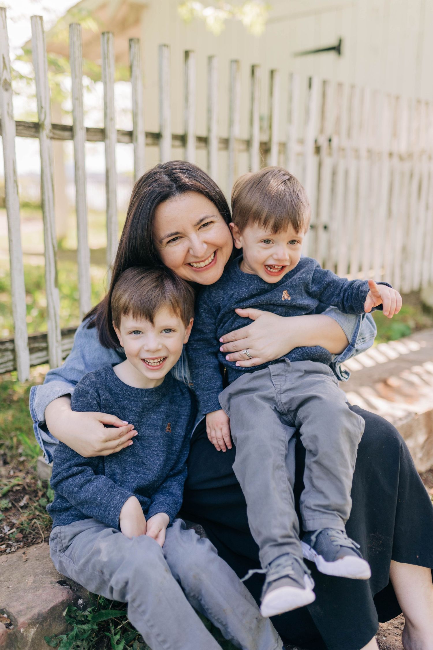 Family sharing genuine laughter and embraces while sitting together outdoors.