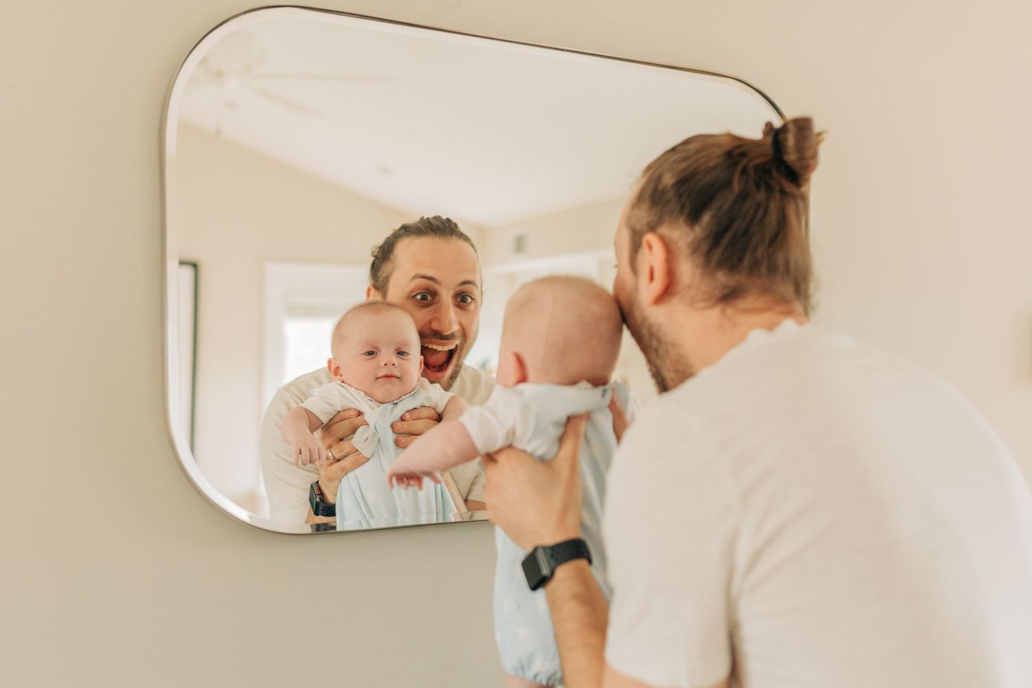 Family shares tender moments together in bright room with mirror.