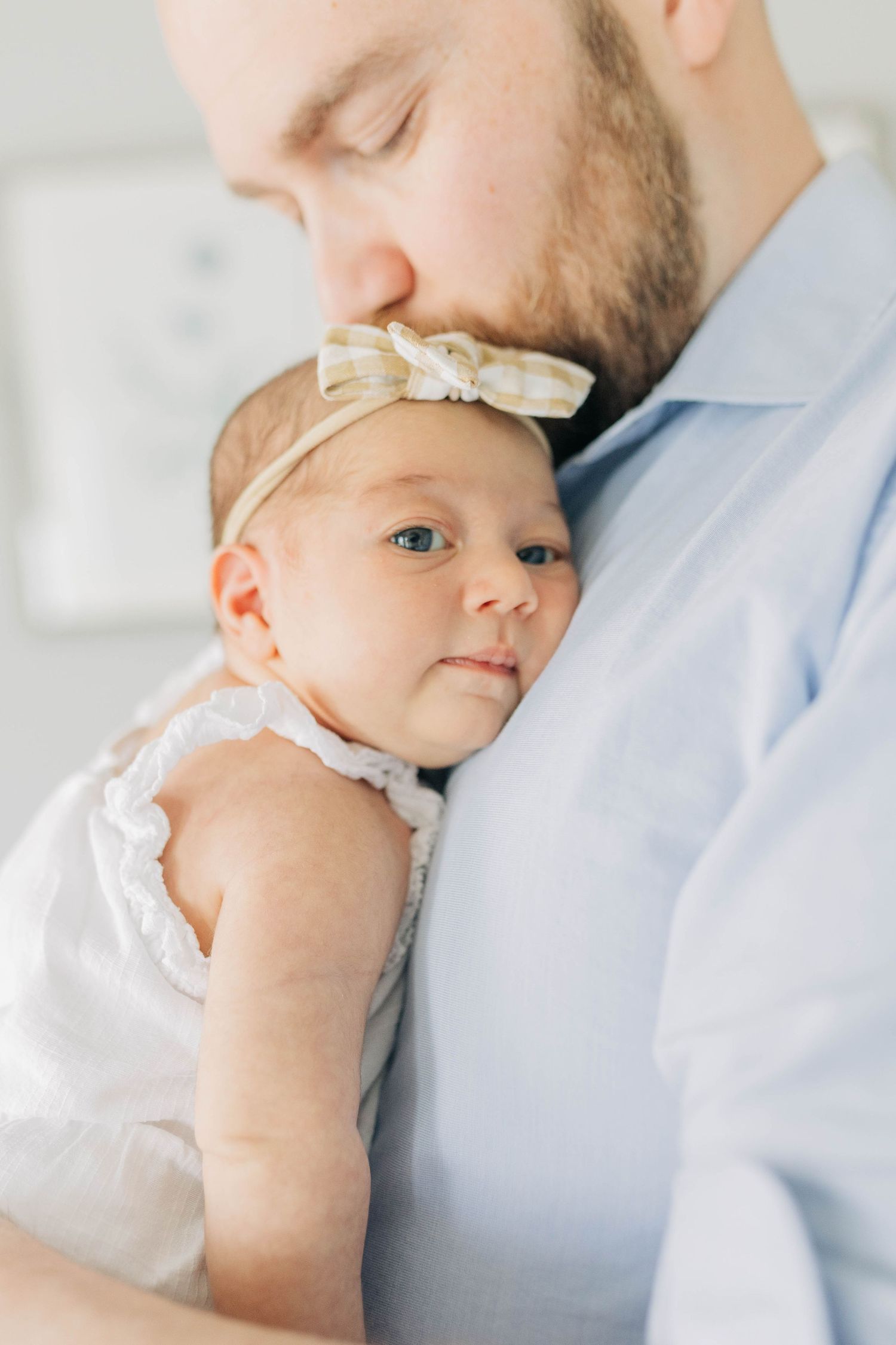 Close-up shots of tender moments between parent and baby in gentle lighting.