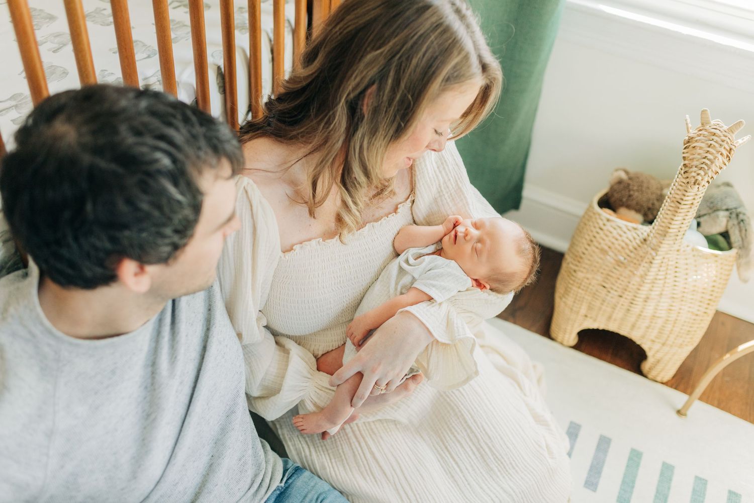 Sweet family bonding moment in modern nursery with natural lighting.