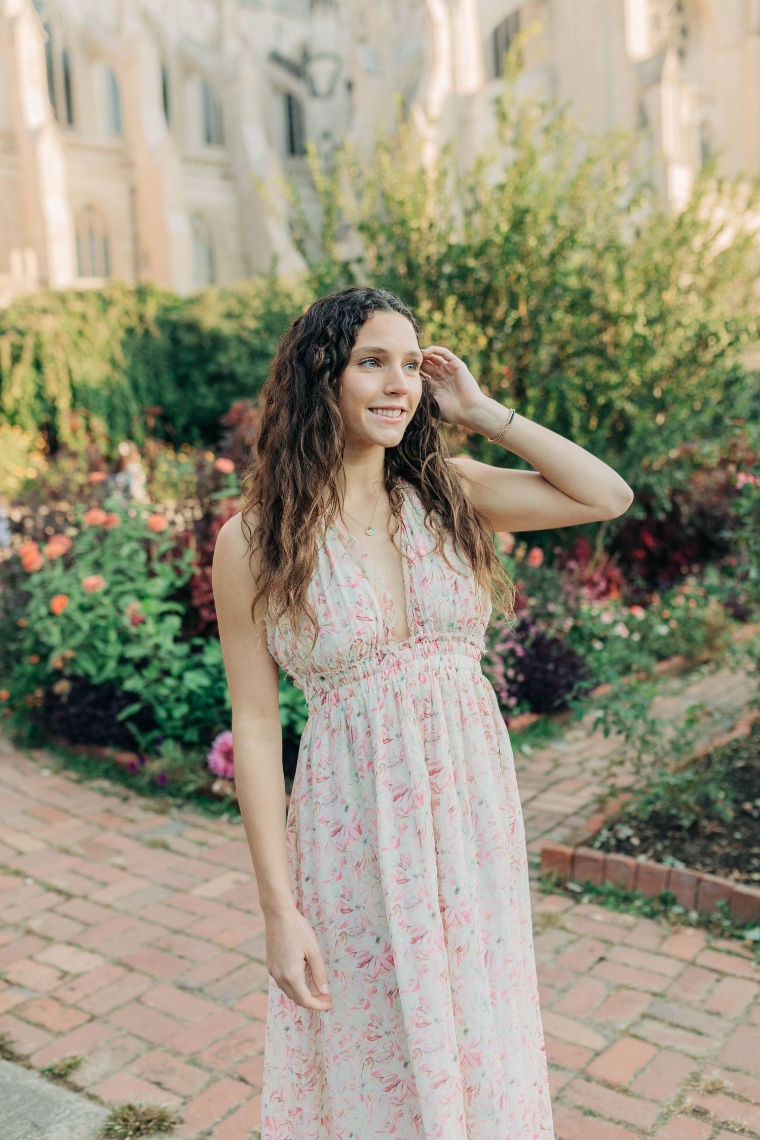 Brick pathway lined with colorful flowers provides a charming garden setting for portraits.